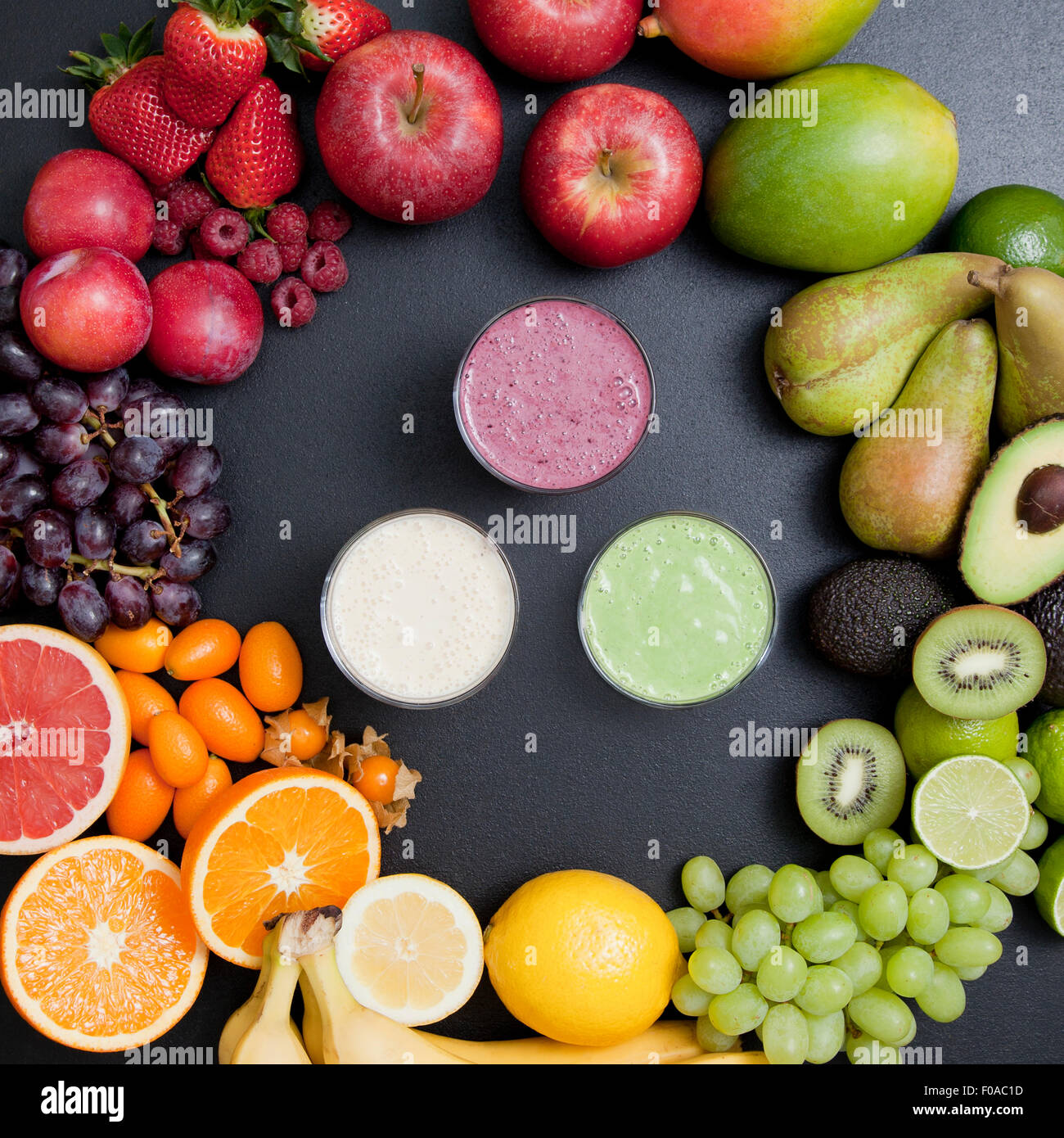 Tettuccio di vita ancora di varietà di frutta fresca che circonda i frullati Foto Stock
