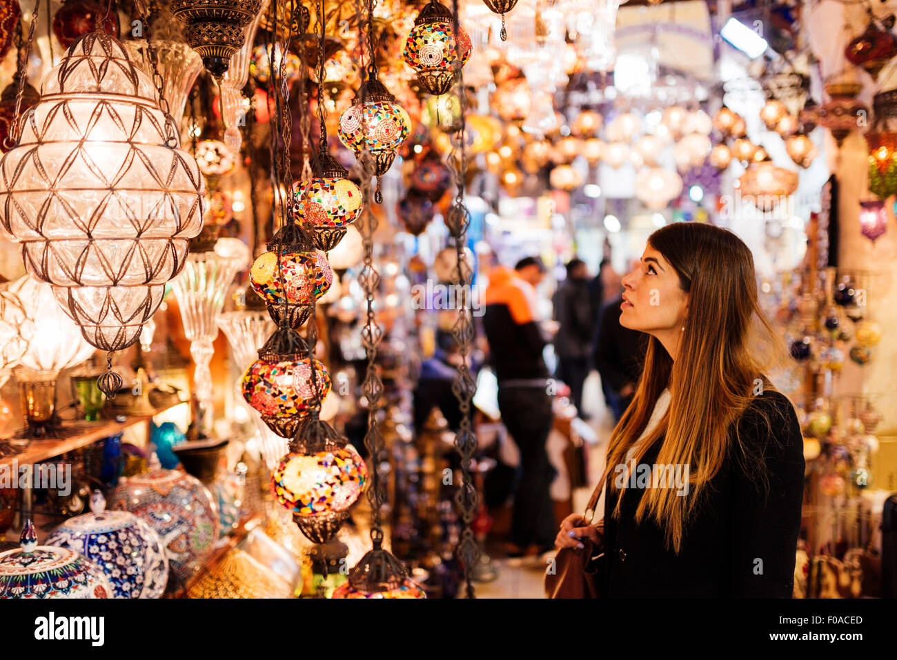 Giovane donna guardando luci sul mercato in stallo, Istanbul, Turchia Foto Stock