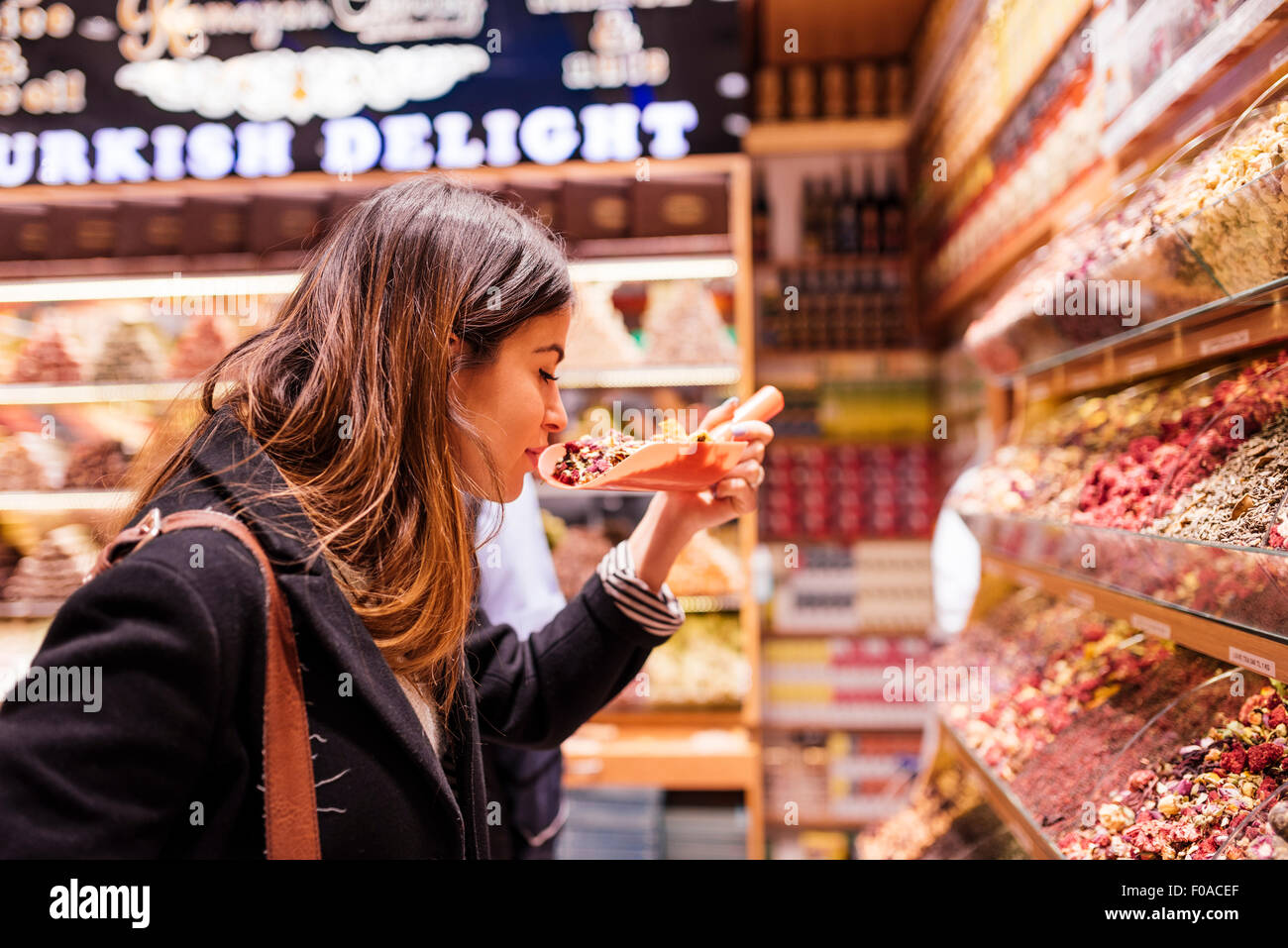 Giovane donna odore di cibo nel mercato, Istanbul, Turchia Foto Stock