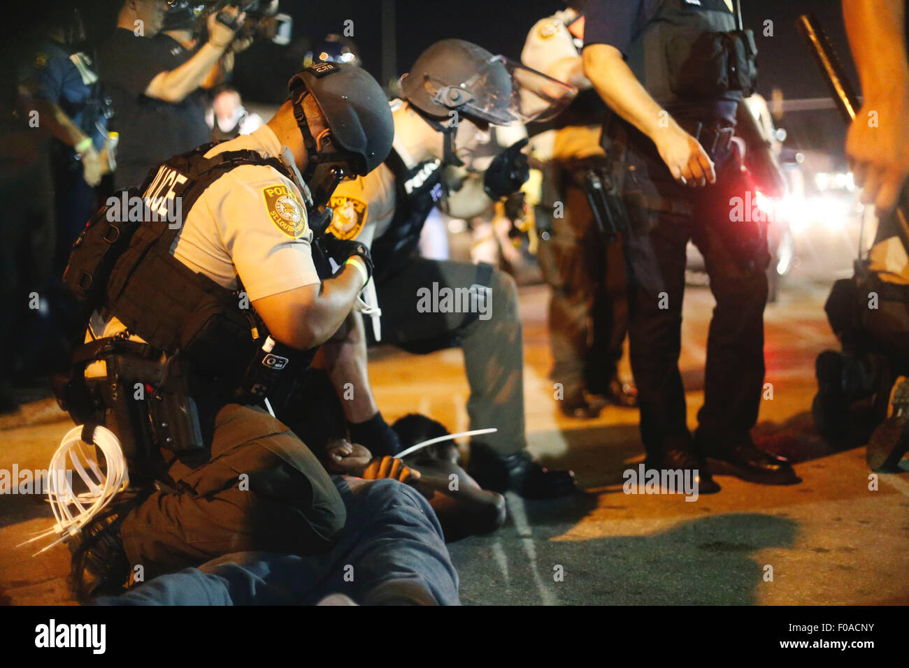 Ferguson, STATI UNITI D'AMERICA. 10 Ago, 2015. La polizia arresta i manifestanti su una strada di Ferguson, Missouri, Stati Uniti, il 10 agosto 2015. Lo stato di emergenza è stato dichiarato per la città di Ferguson il lunedì seguente la pistola battaglia tra polizia e manifestanti Domenica notte dell'anniversario di Michael Brown della morte. Credito: Jim Vondruska/Xinhua/Alamy Live News Foto Stock