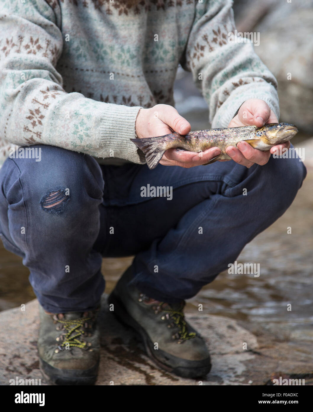 Uomo con il pesce appena pescato Foto Stock