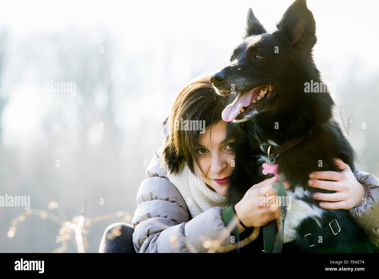 Ritratto di metà donna adulta abbracciando il suo cane Foto Stock