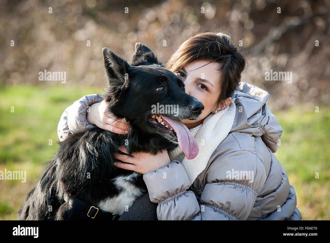 Ritratto di metà donna adulta baciare il suo cane nel campo Foto Stock