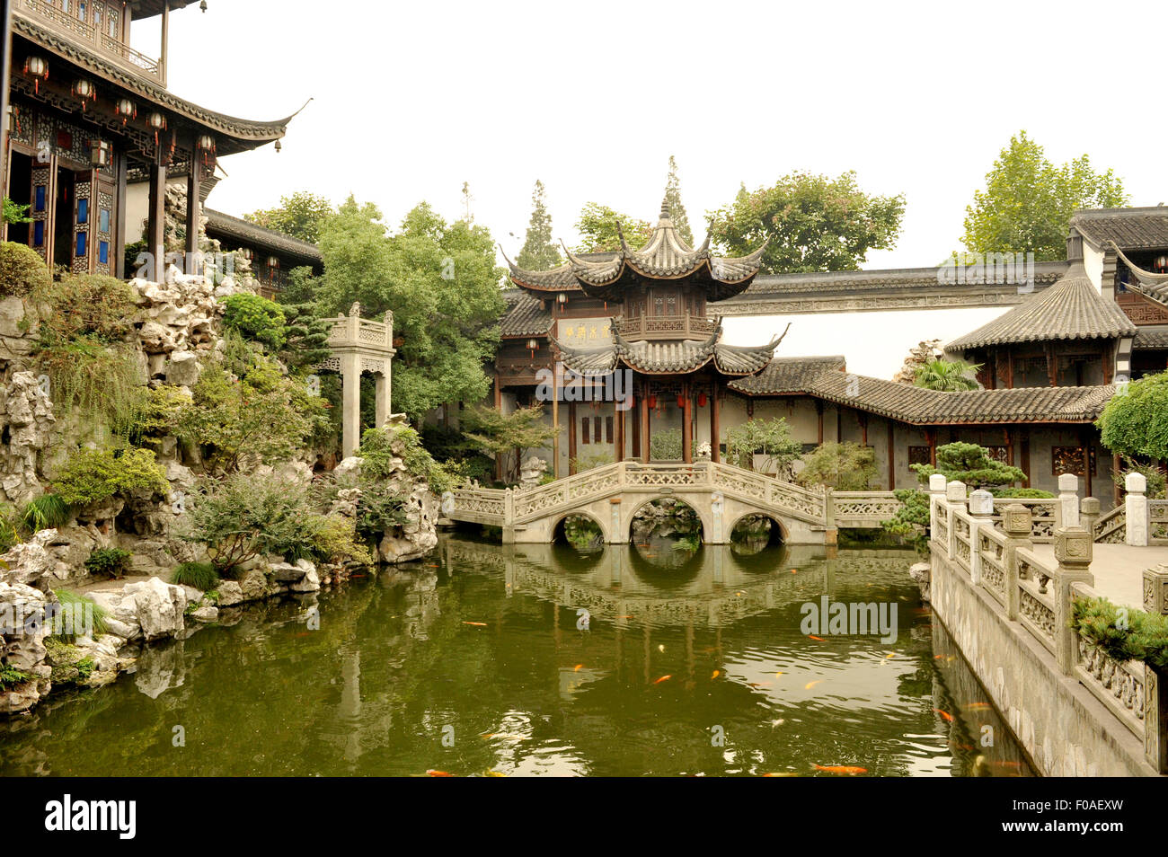 Cinese tradizionale giardino con piscina di pesce, il ponte di pietra e padiglioni, Hangzhou, Cina Foto Stock