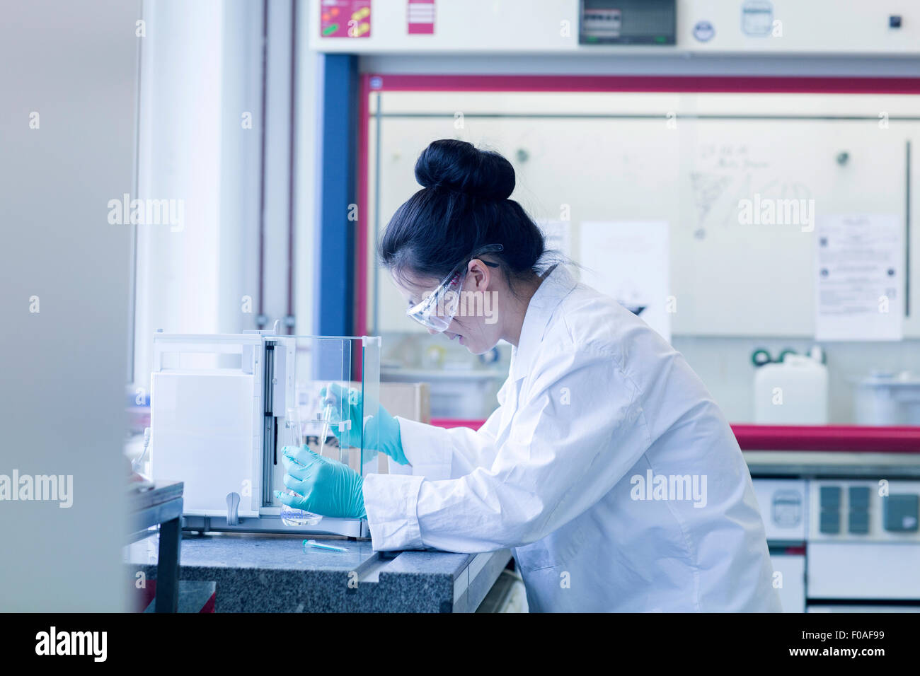 Giovani donne scienziato in laboratorio campione di pipettaggio Foto Stock