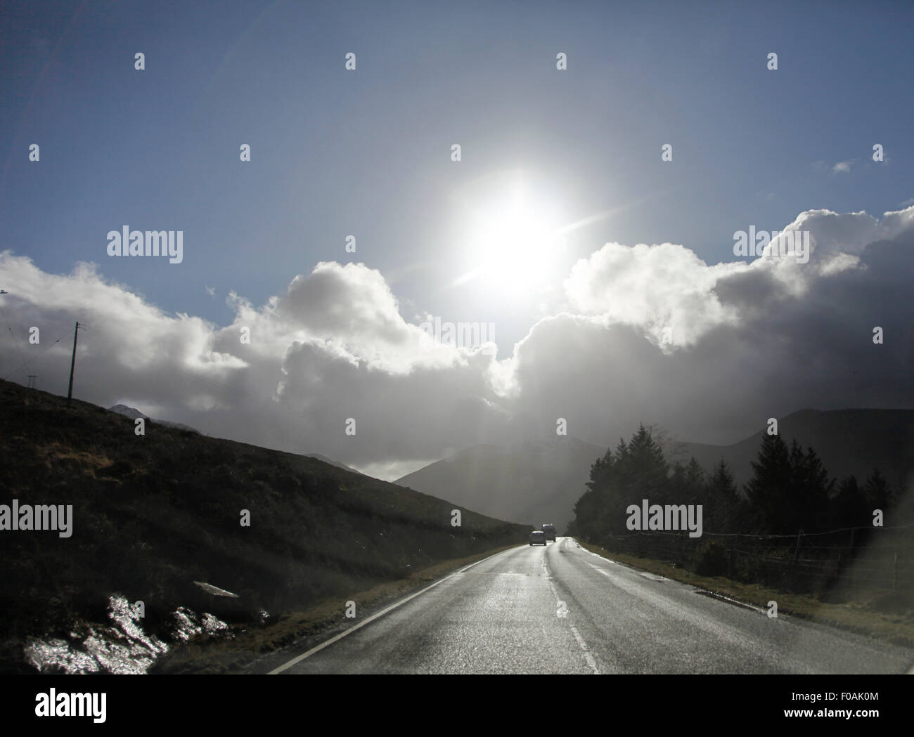 Driver vista lungo la strada di campagna in sun Foto Stock