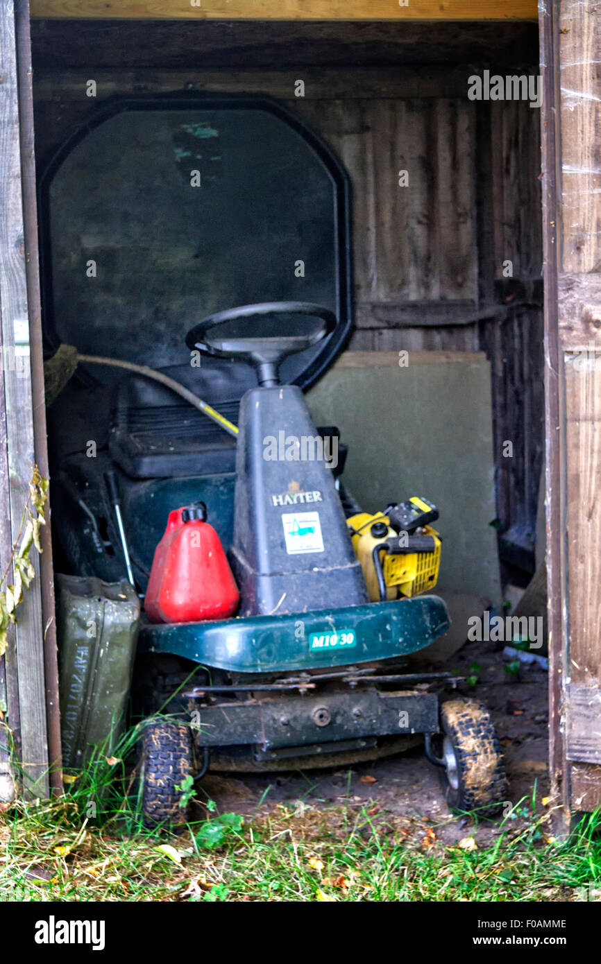 Corsa sulla falciatrice memorizzati in un capannone di legno Foto Stock