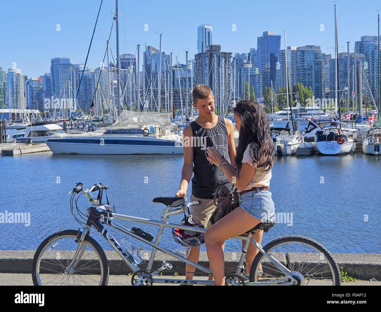 Giovane con ciclo a Stanley Park di fronte del porto di Vancouver, British Columbia, Canada Foto Stock