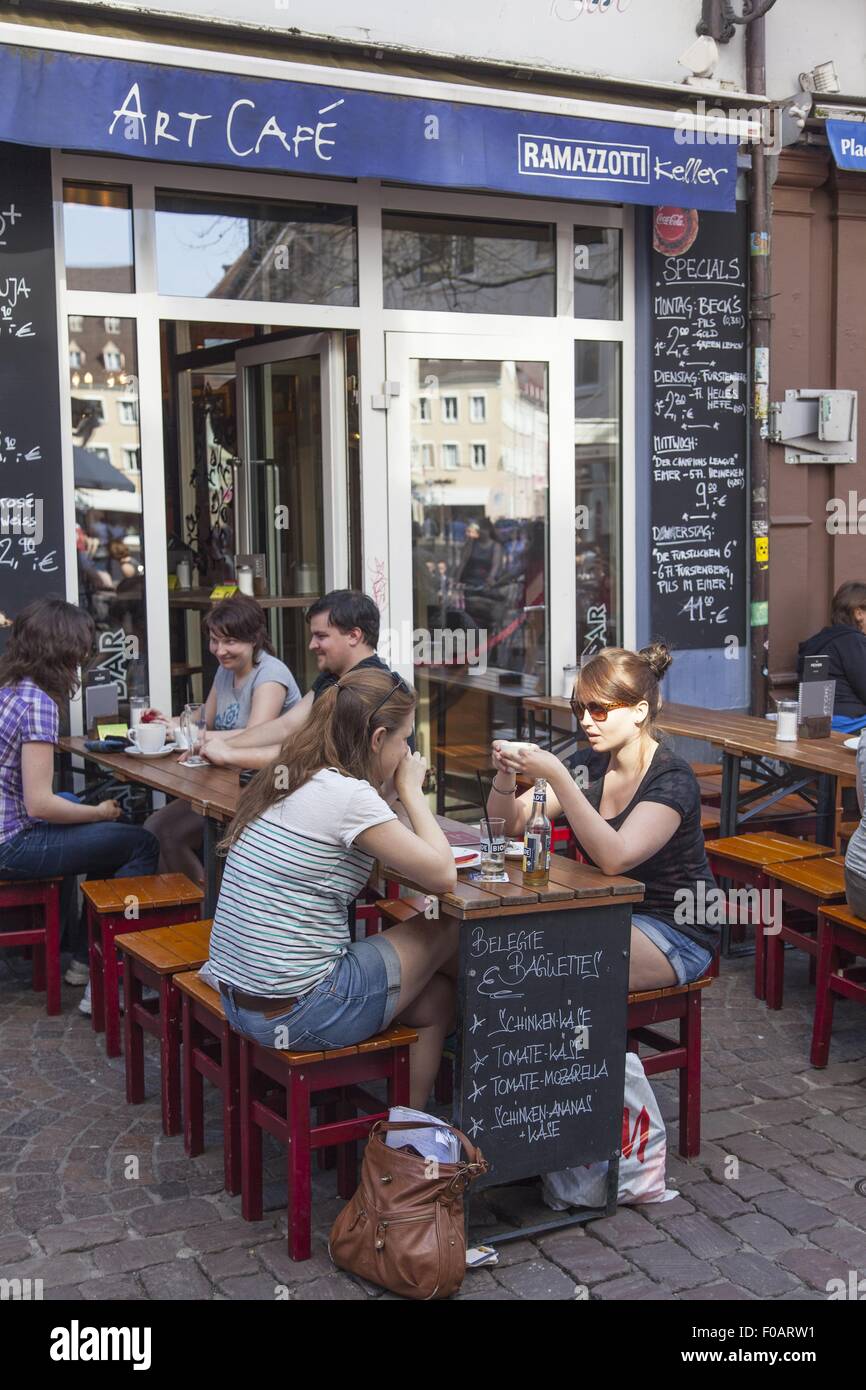 Le persone al di fuori seduta Art Cafe nella Città Vecchia a Friburgo in Germania Foto Stock
