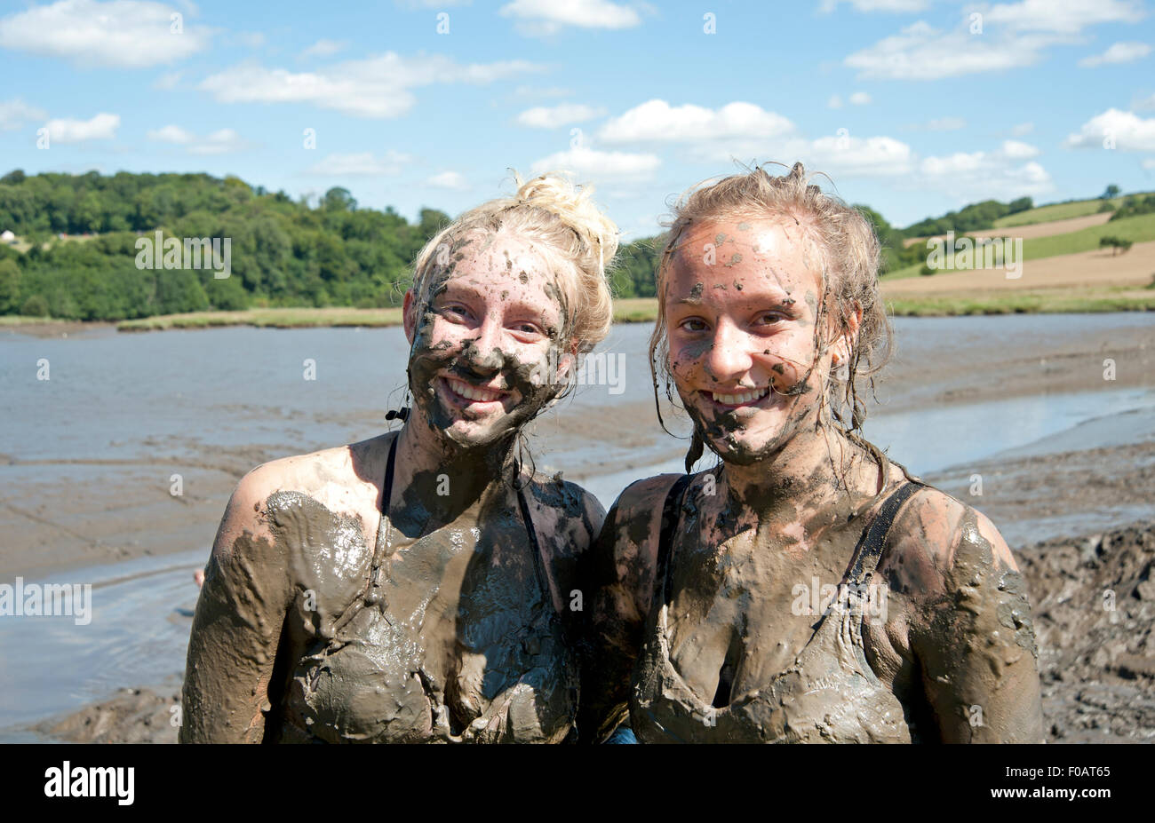 Due giovani ragazze incrostato di fango dopo la riproduzione nel fiume fangoso letto mentre la marea era fuori del porto Eliot Festival Foto Stock