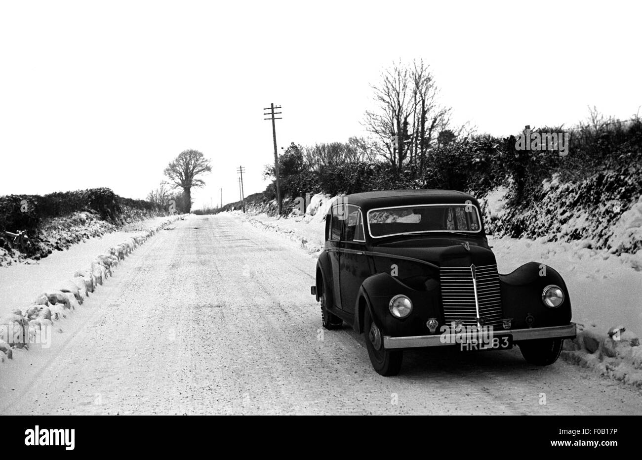 Una vettura in piedi su una coperta di neve road Foto Stock