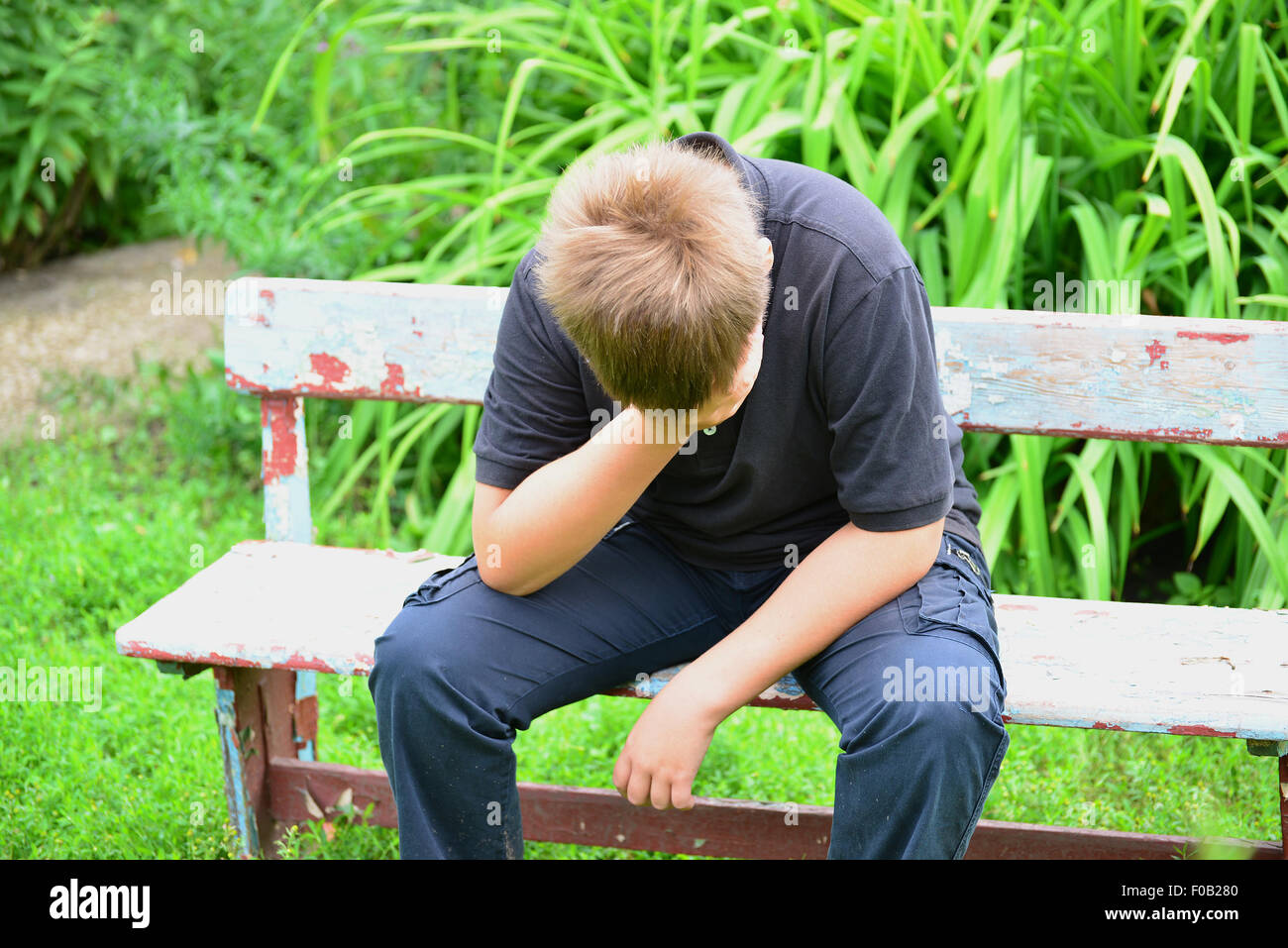 Un adolescente depresso seduta sul banco di lavoro Foto Stock