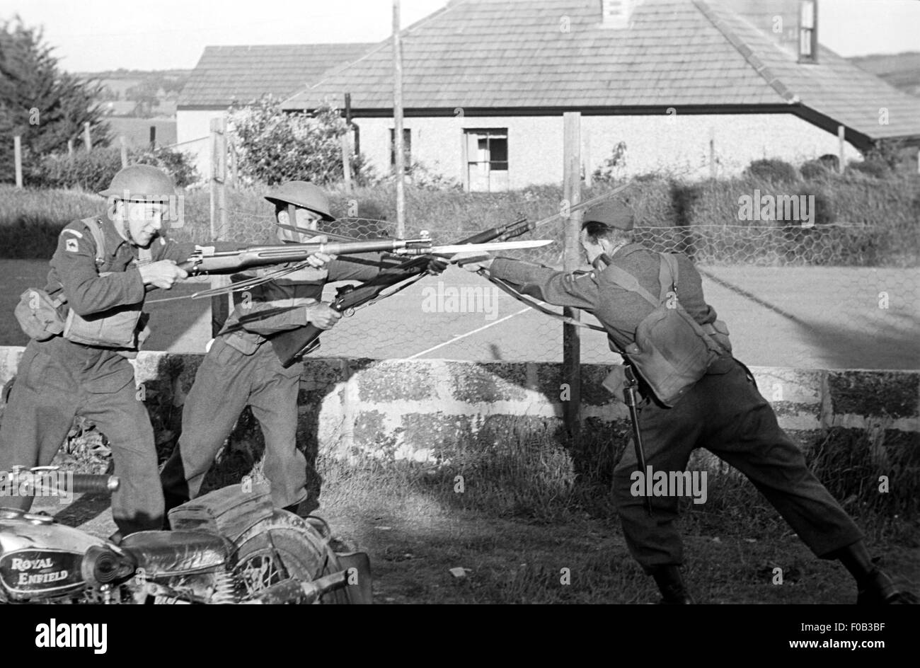 Tre uomini nelle forze armate di uniformi di formazione con baionette fisso in tempo di guerra la Gran Bretagna. Foto Stock