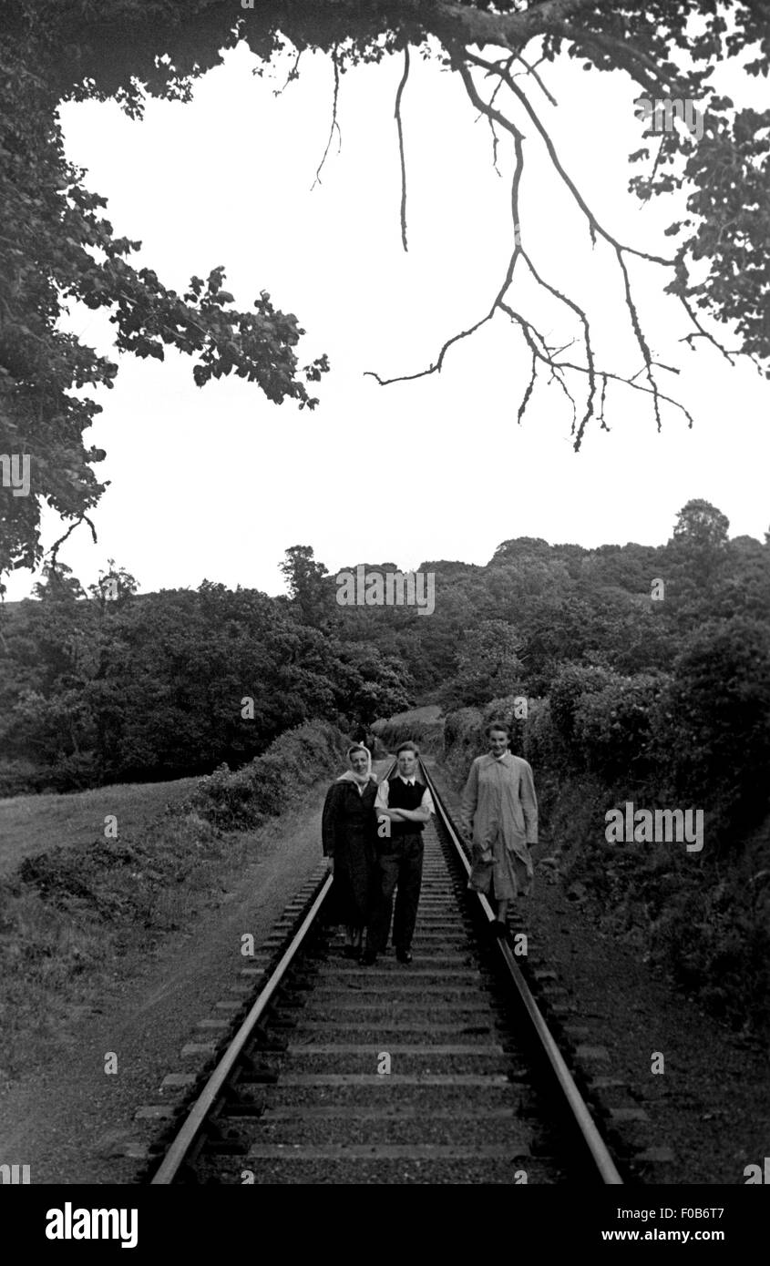 Due donne di mezza età e un giovane uomo in piedi sul treno le vie del paese Foto Stock