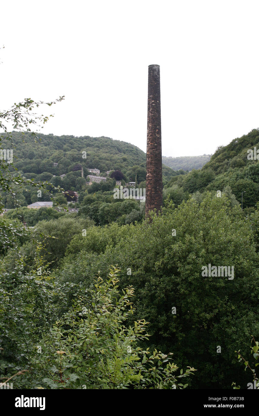 Vecchia fabbrica torri camino al di sopra della valle di città di Hebden Bridge, Yorkshire Foto Stock