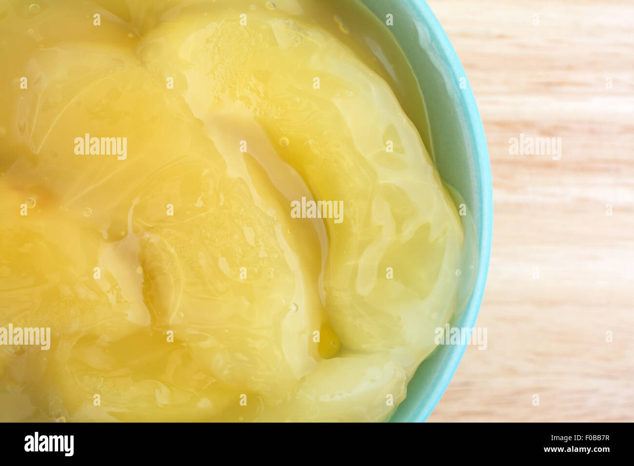 Top vista ravvicinata di un verde ciotola riempita con le conserve di torta di mele ripieno su una tavola di legno top illuminato con luce naturale. Foto Stock