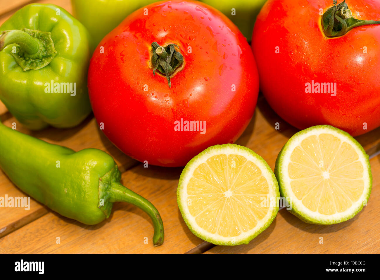 Wet pomodori, peperone verde, il pepe verde e fette di mezzo limone pezzi Foto Stock