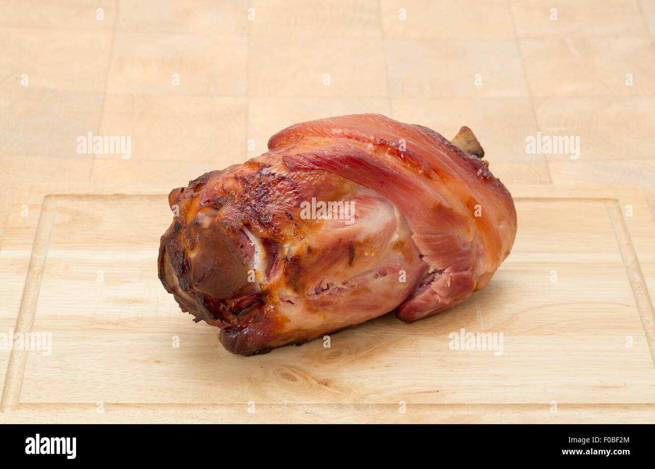 Arrosto di maiale gammon gambo su un tagliere di legno Foto Stock