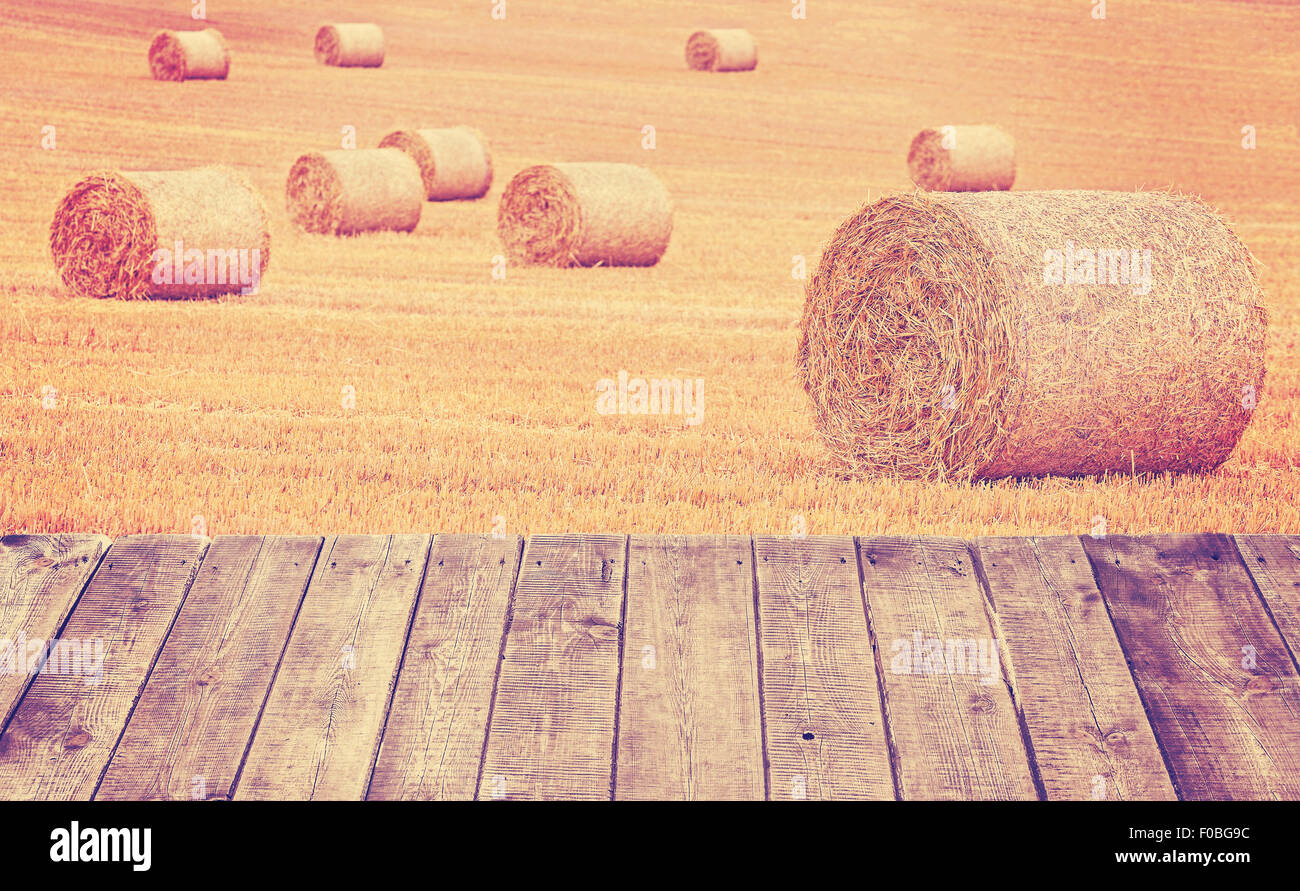 Vintage tonica balle di fieno su un campo con assi di legno. Foto Stock