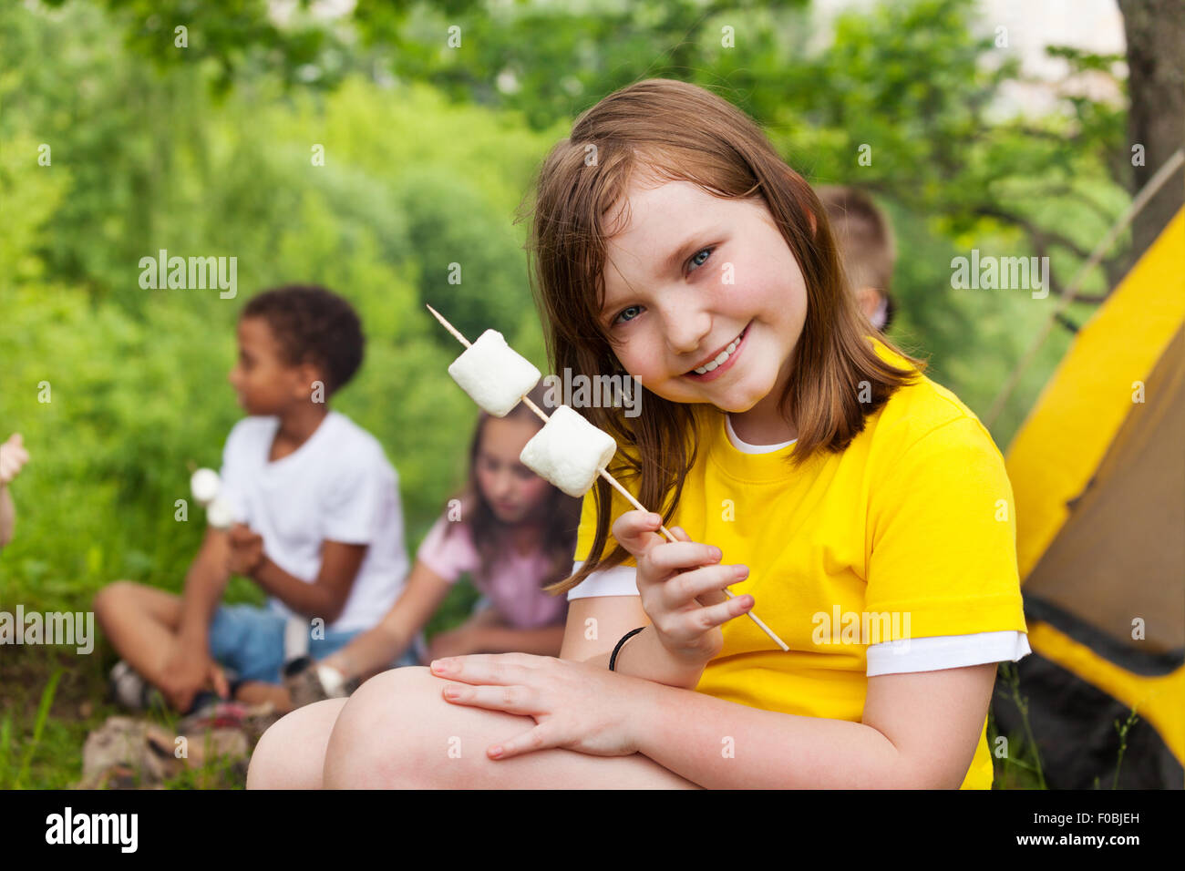 Bella ragazza tenendo marshmallows vicino alla tenda Foto Stock
