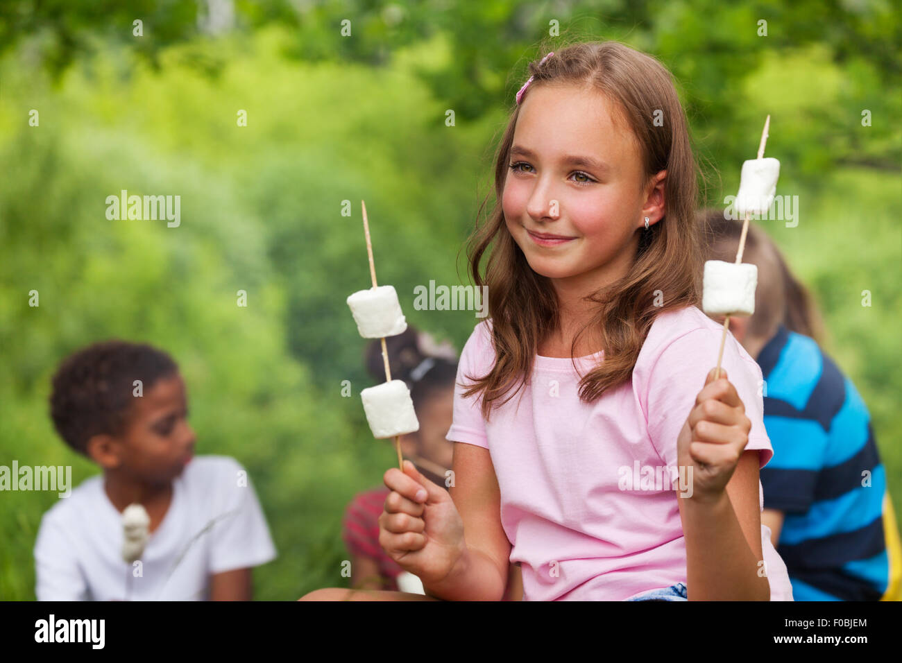 Sorridente ragazza con marshmallows vicino alla tenda Foto Stock