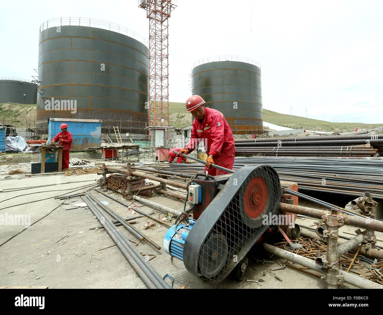 Nagqu, la Cina della regione autonoma del Tibet. 10 Ago, 2015. Un lavoratore installa una macchina in un progetto per aggiornare un serbatoio di olio nella prefettura di Nagqu, a sud-ovest della Cina di regione autonoma del Tibet, il 10 agosto 2015. Il serbatoio olio, il quale è azionato da PetroChina, Cina la più grande compagnia petrolifera, si trova ad un altitudine di 4.600 metri e vanta il più alto serbatoio olio nel mondo. © Chen Jianli/Xinhua/Alamy Live News Foto Stock