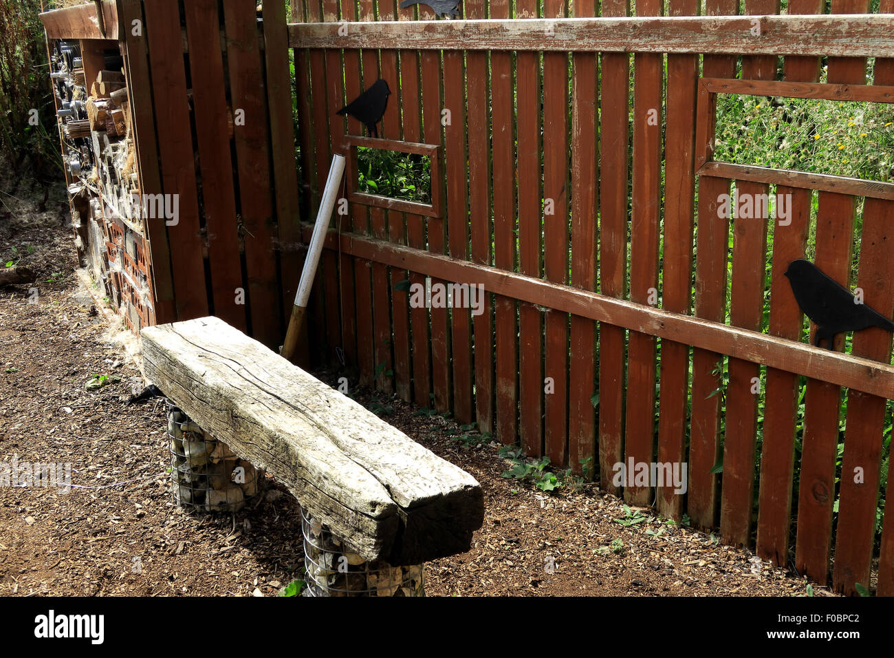 Un banco di legno dietro un recinto con intagli in per il bird-watching Foto Stock