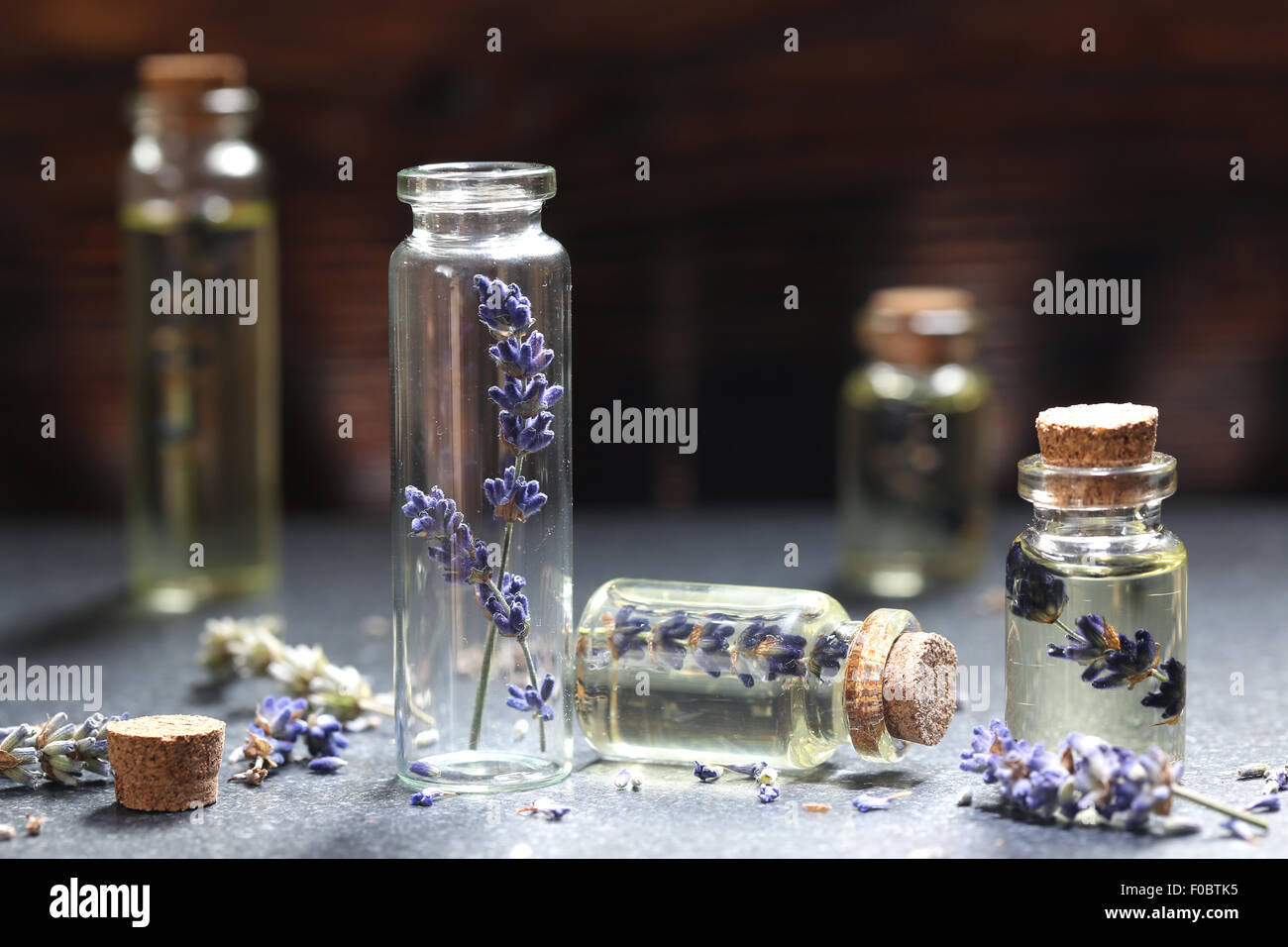 Olio di lavanda in una bottiglia di vetro su di un tavolo di legno Foto Stock