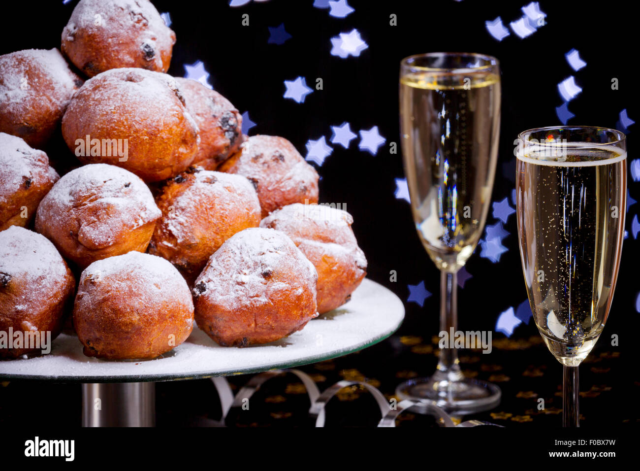 "Oliebollen', tradizionale pasticceria olandese per la Vigilia di Capodanno e due bicchieri di champagne. Foto Stock