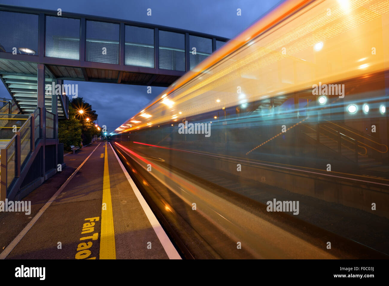 Ad alta velocità ferroviaria intercity in movimento e la stazione di Athenry di notte, Irlanda Foto Stock