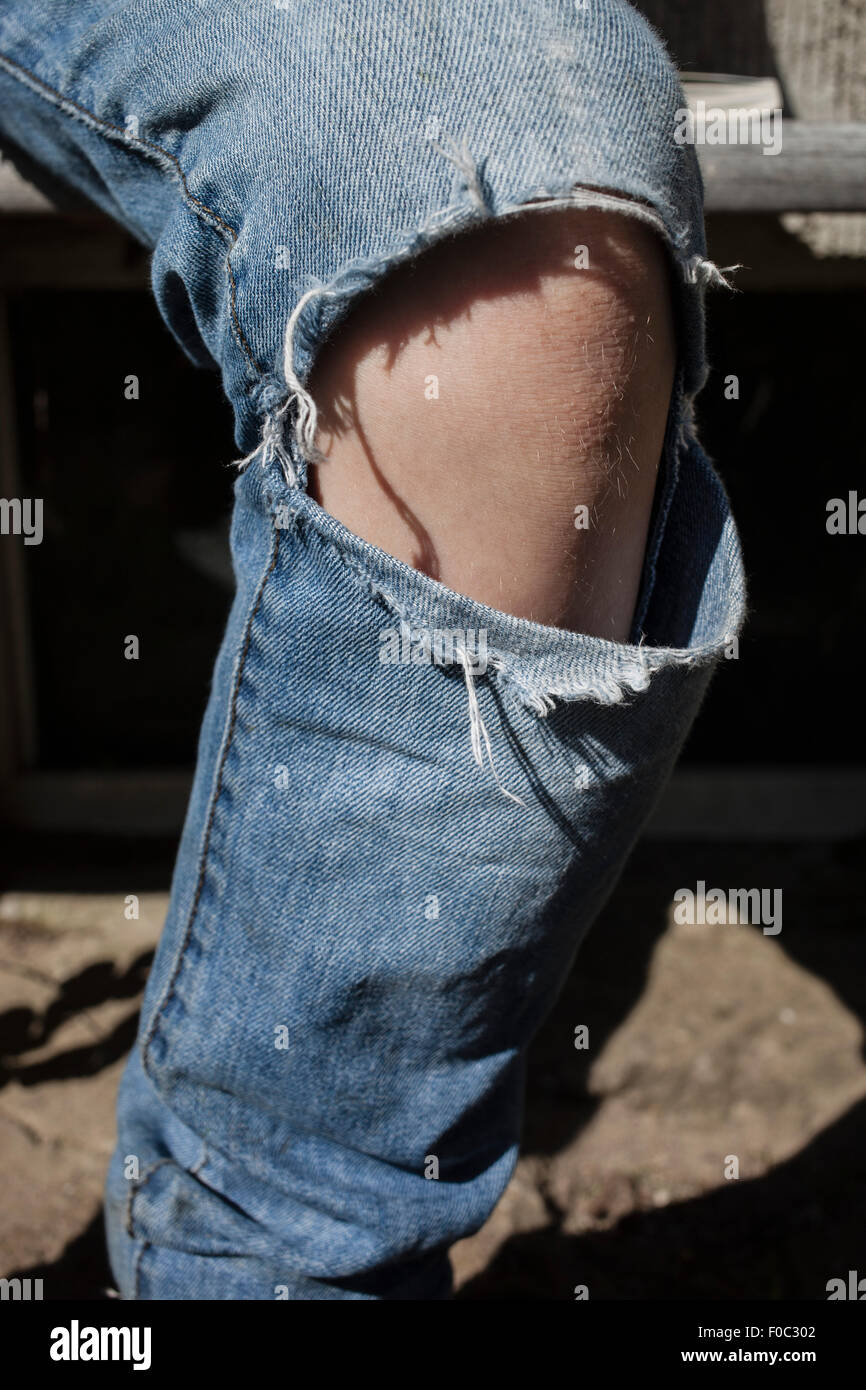 Close-up della persona che indossa jeans strappati Foto Stock