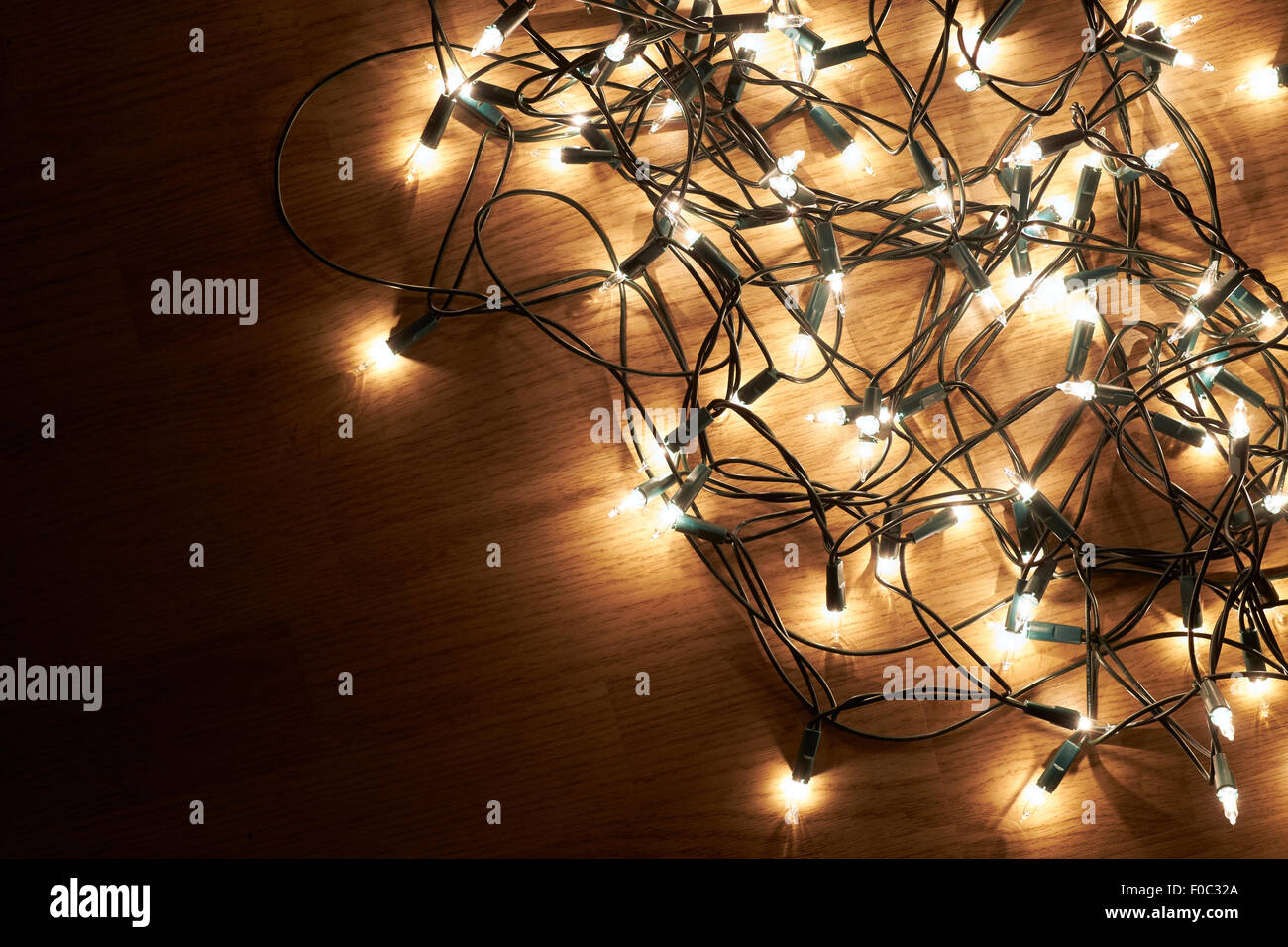 Tradizionali di Natale luci ad albero giacente su un pavimento di legno. Foto Stock