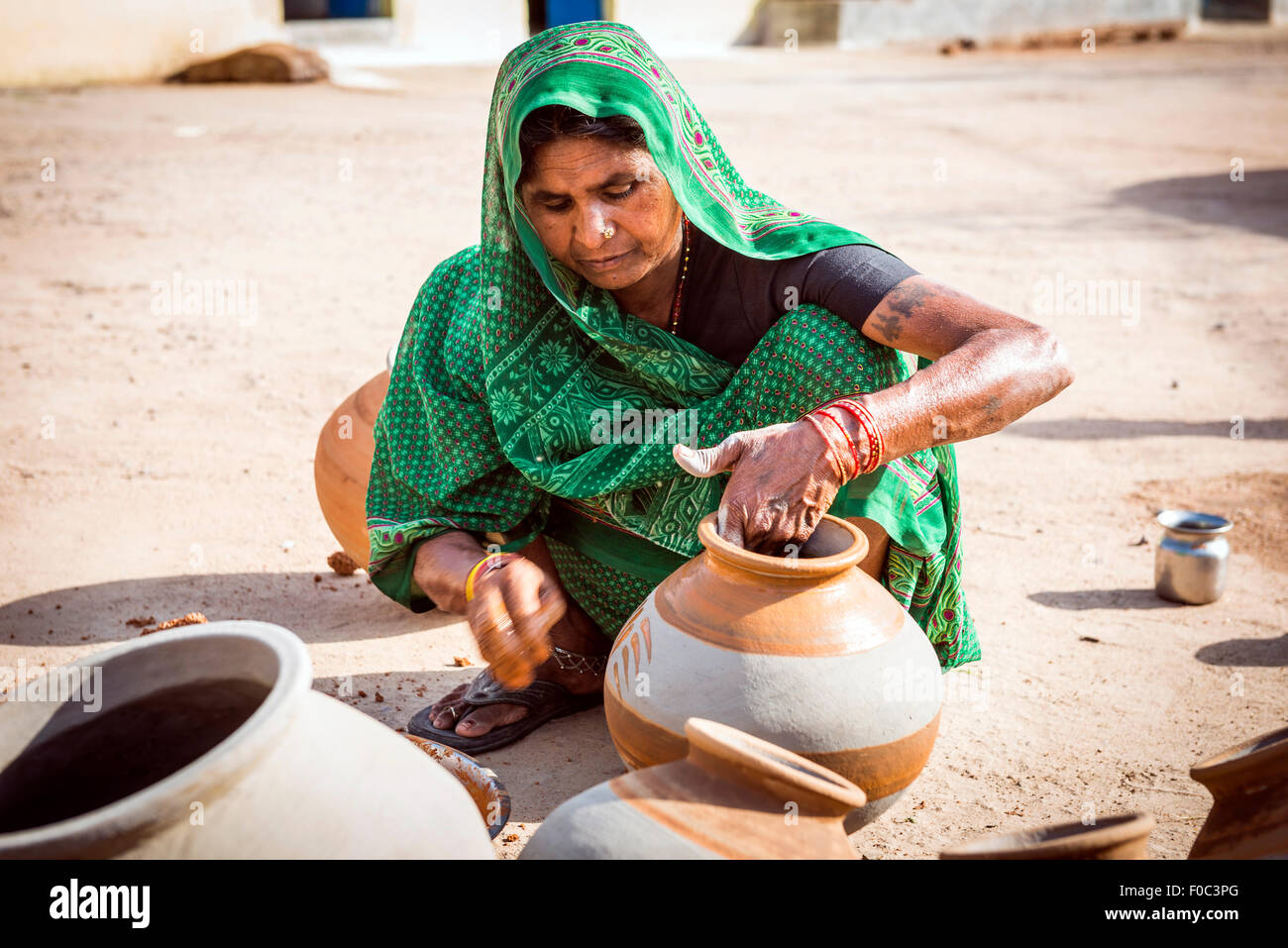 Potter la moglie di decorare pots tradizionale nella parte vecchia di Khajuraho, Madhya Pradesh, India Foto Stock