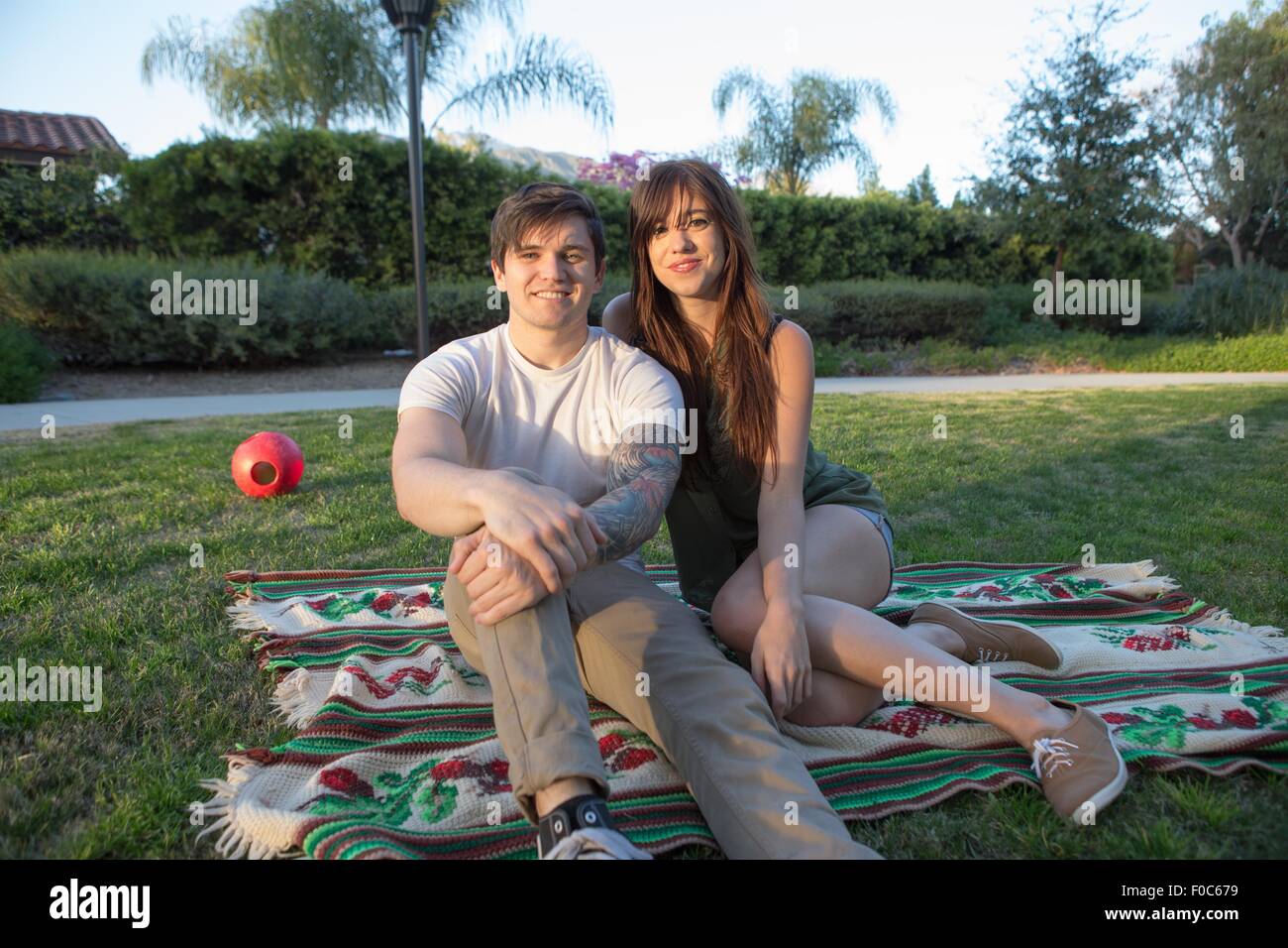 Ritratto di una giovane coppia in coperta picnic nel parco Foto Stock