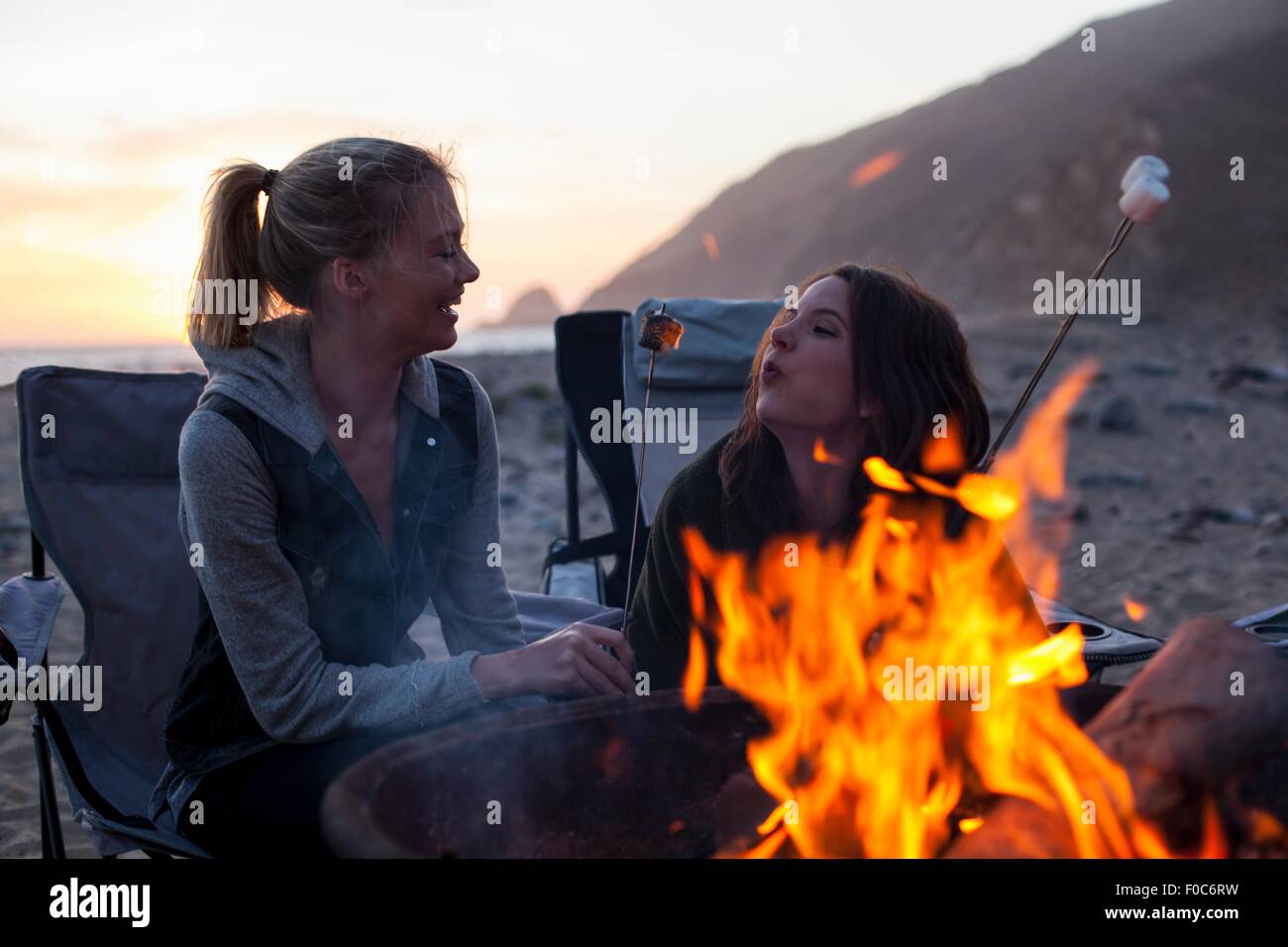 Fidanzate avente barbecue sulla spiaggia, Malibu, California, Stati Uniti d'America Foto Stock