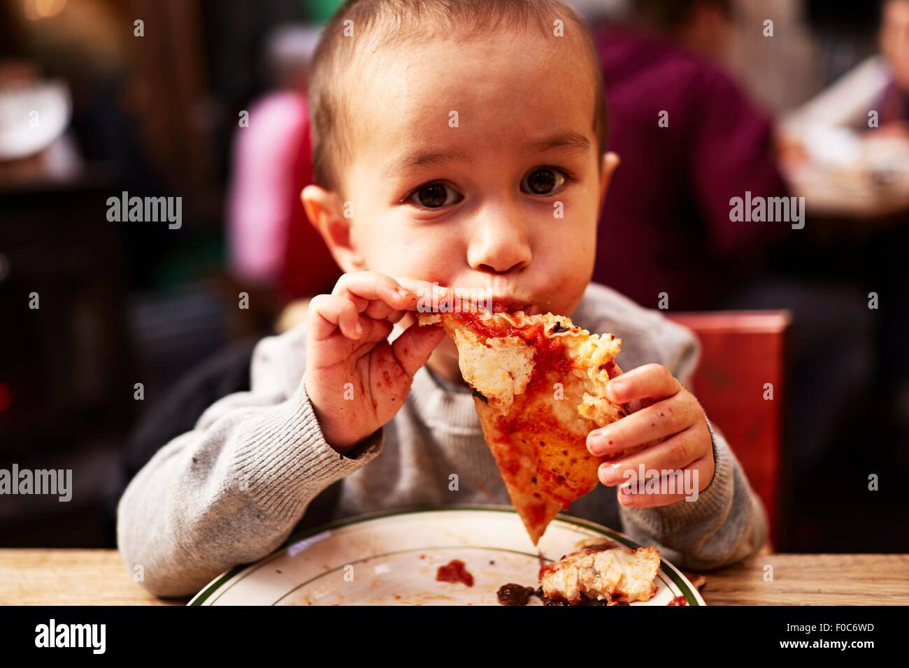 Ragazzo di mangiare la pizza nel ristorante Foto Stock