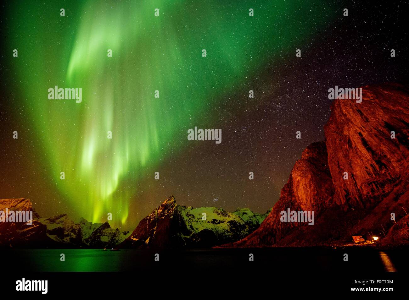 Vista di aurora boreale sopra il livello del mare e delle montagne innevate, la Reine, Norvegia Foto Stock