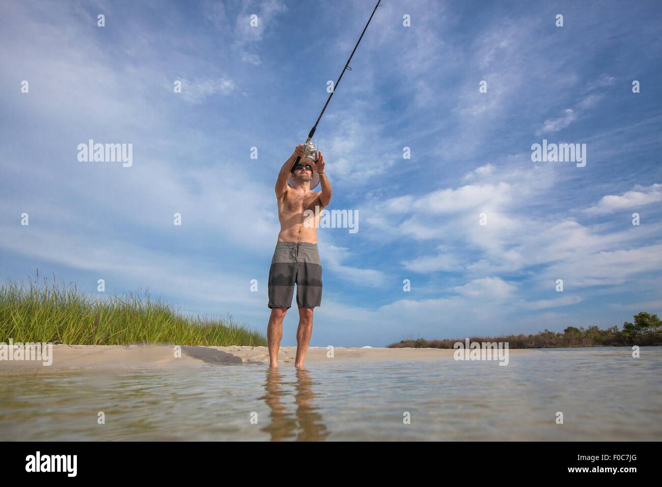 Basso angolo di visione dell uomo maturo pesca, Fort Walton, Florida, Stati Uniti d'America Foto Stock