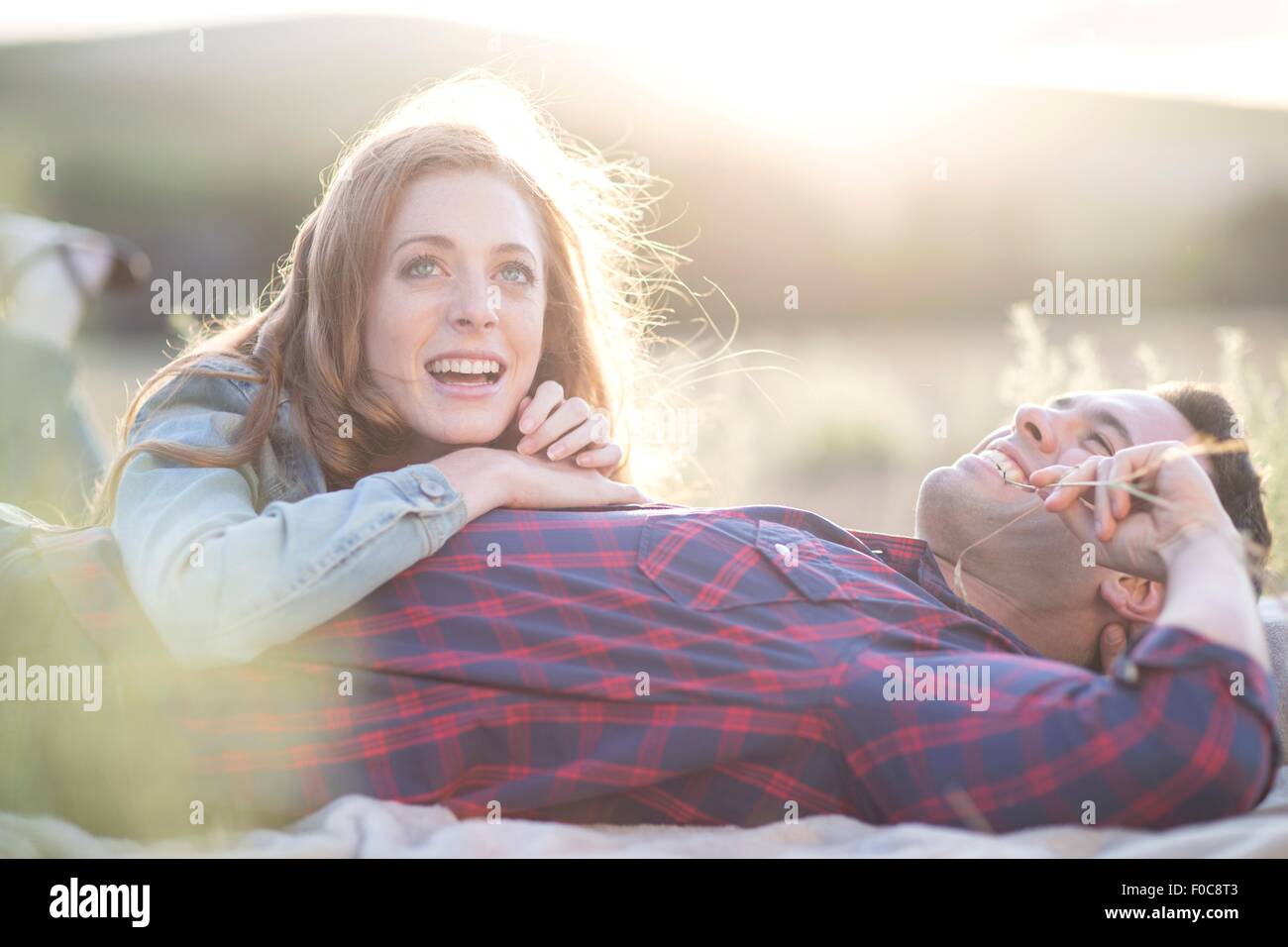 Coppia giovane giacente insieme da masticare erba paglia Foto Stock