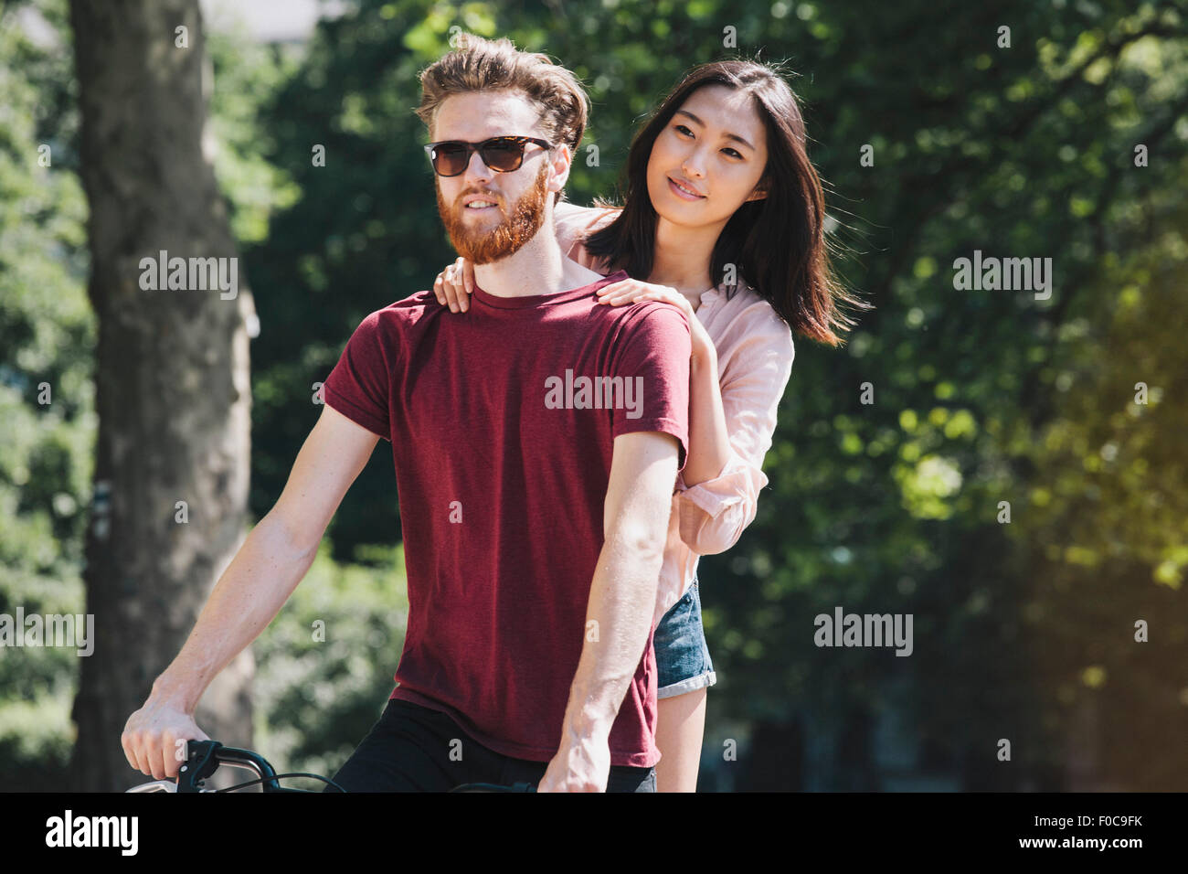 Coppia giovane equitazione bicicletta in posizione di parcheggio Foto Stock