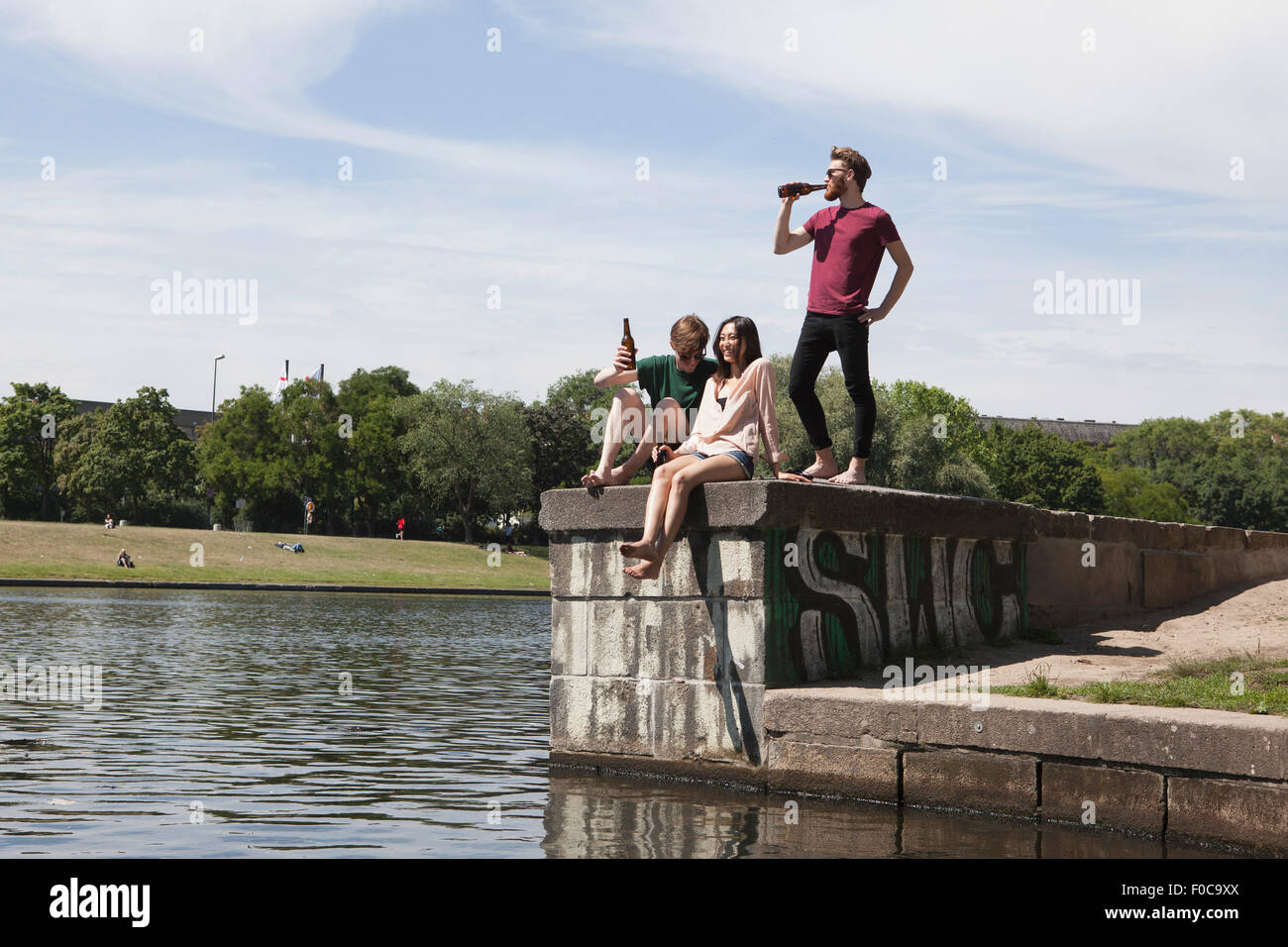 Multi-etnico amici godendo sulla parete di ritegno da canal Foto Stock