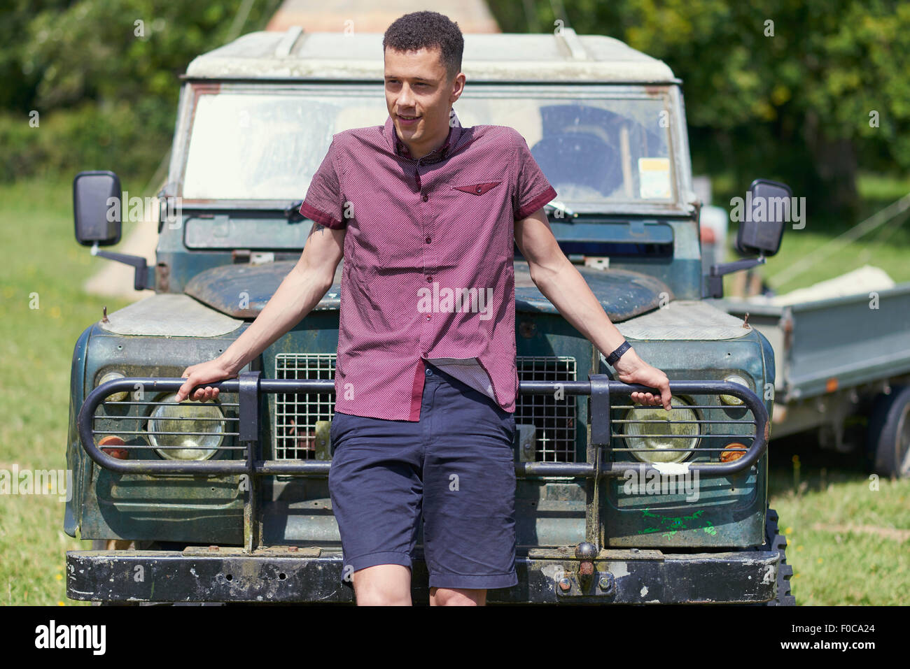 Giovane uomo appoggiato sul carrello in posizione di parcheggio Foto Stock