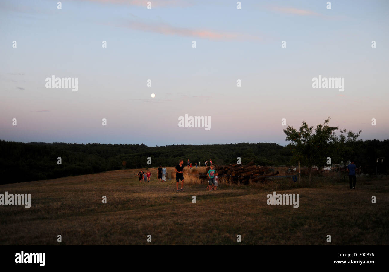 La luna piena sorge al tramonto durante la serata Picnic a Loubejac che è un piccolo comune o villaggio in Dordogne Francia Foto Stock