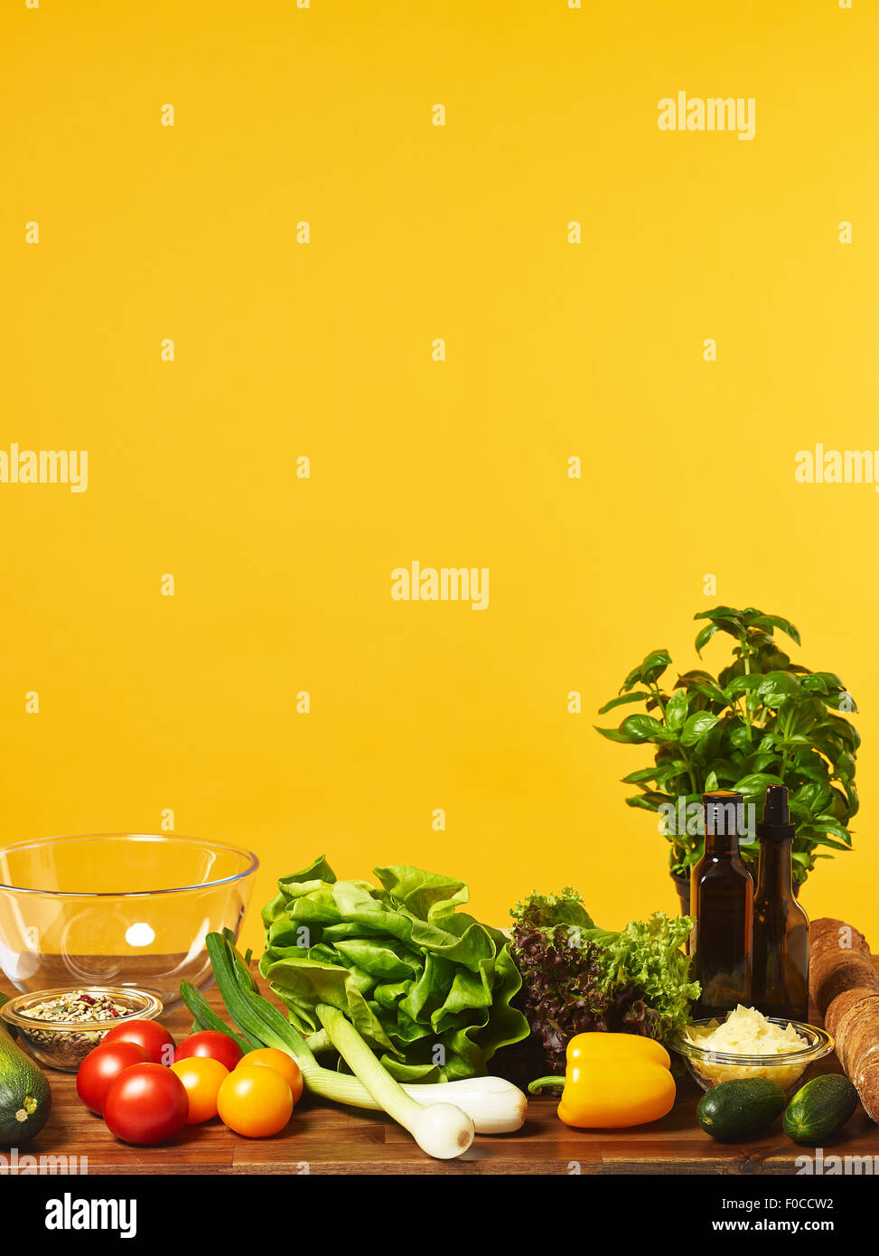 Insalata fresca ingredienti sul tavolo, copia di spazio e di sfondo giallo Foto Stock