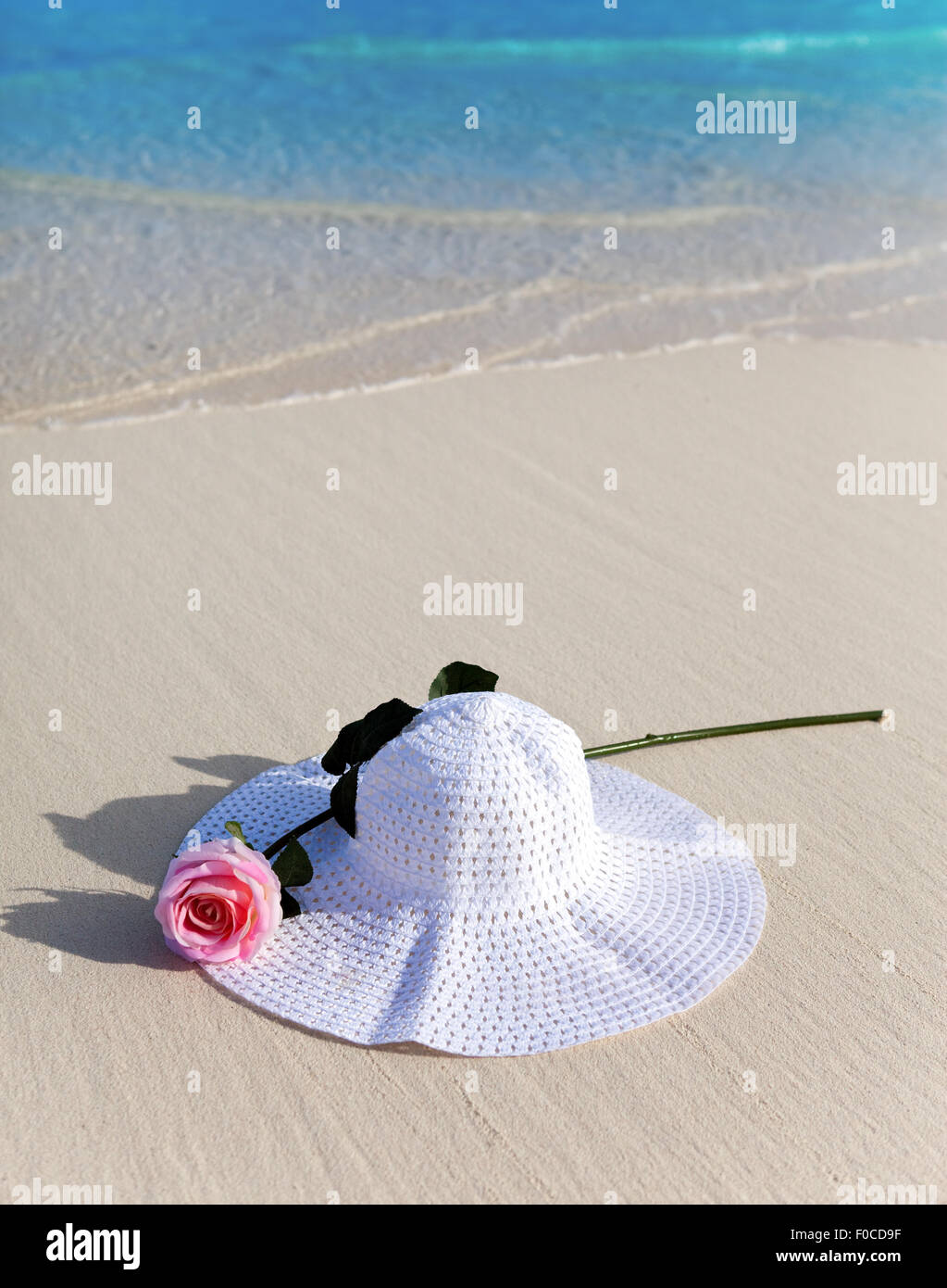 Hat e rose in onde su una spiaggia Foto Stock