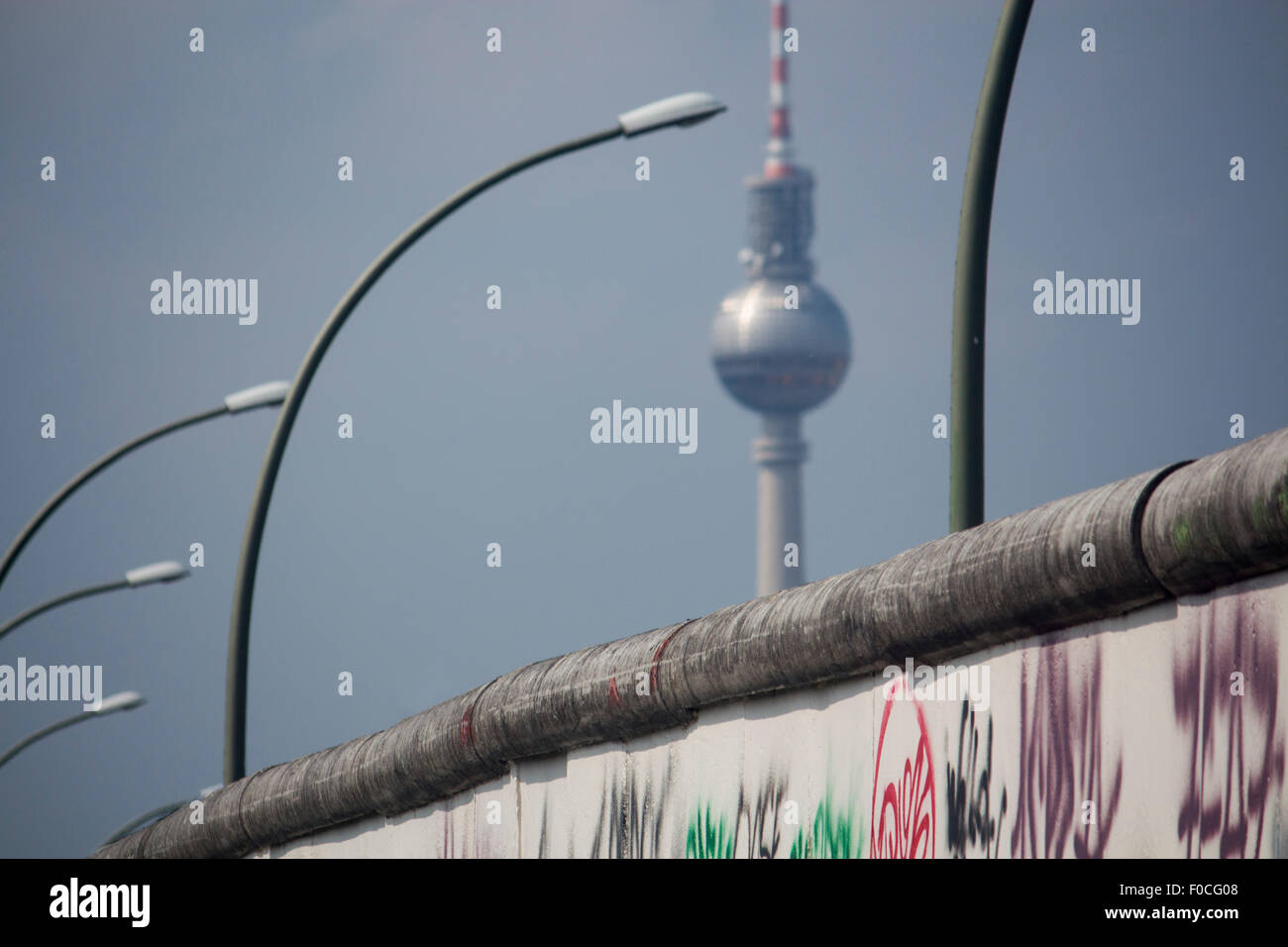 La sezione del muro di Berlino Berliner Mauer e Fernsehturm TV Tower antichi simboli della città divisa Guerra Fredda Berlino Germania Foto Stock