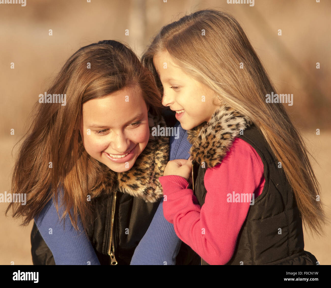 Due sorelle/amici raccontare segreti al di fuori. È tempo di caduta. Luce dolce. Foto Stock