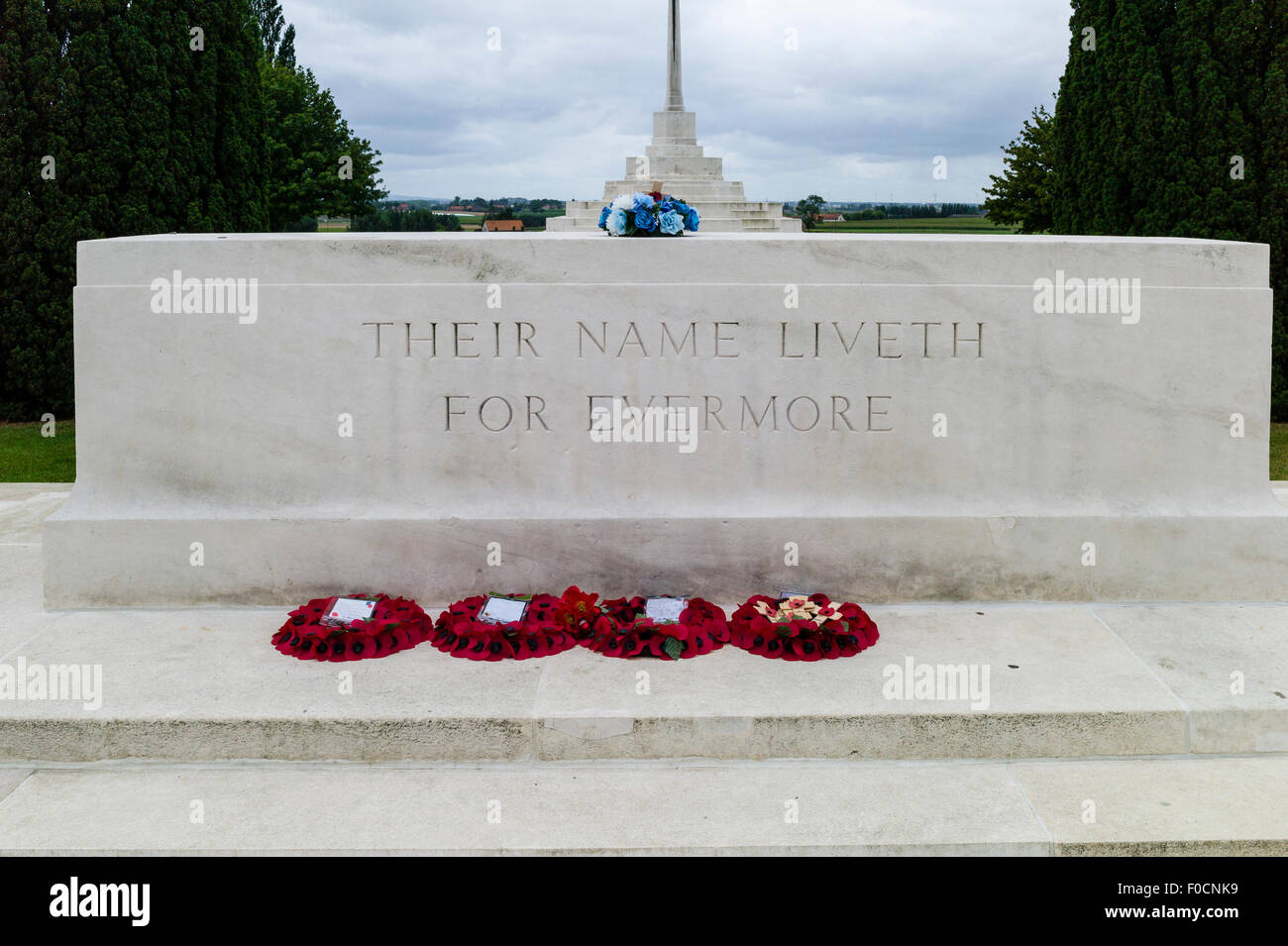 Lapide a Tyne Cot cimitero vicino Ypres, Belgio, con ghirlande di papaveri e altri fiori. Foto Stock