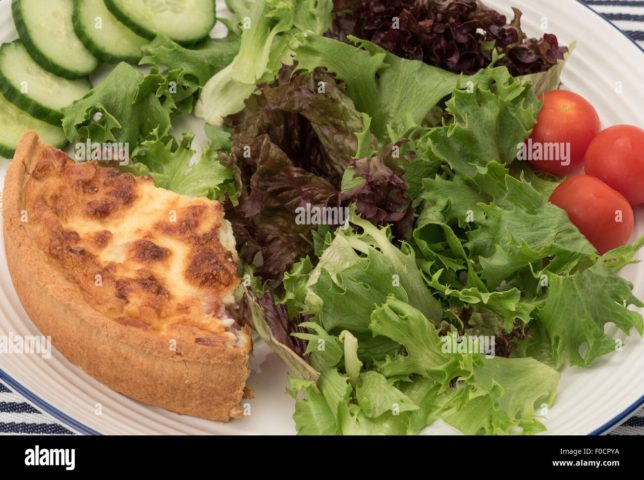 Inquadratura ravvicinata di una fetta di formaggio Quiche Lorraine e una insalata verde Foto Stock