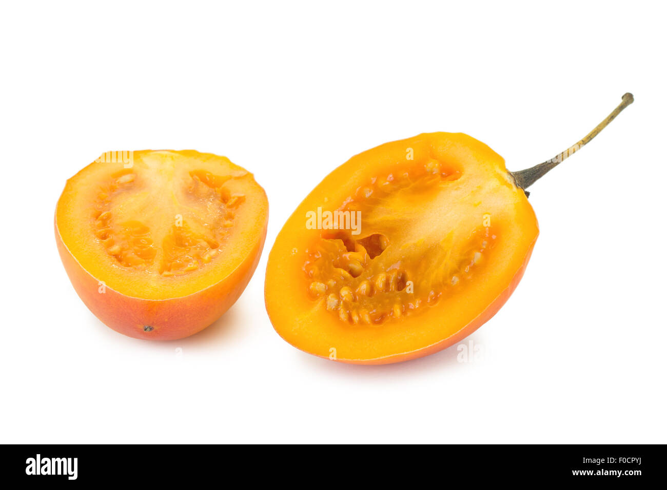 Close-up di un maturo tamarillo (anche noto come albero di pomodoro (Solanum betaceum) tagliato a metà isolato su sfondo bianco. Foto Stock